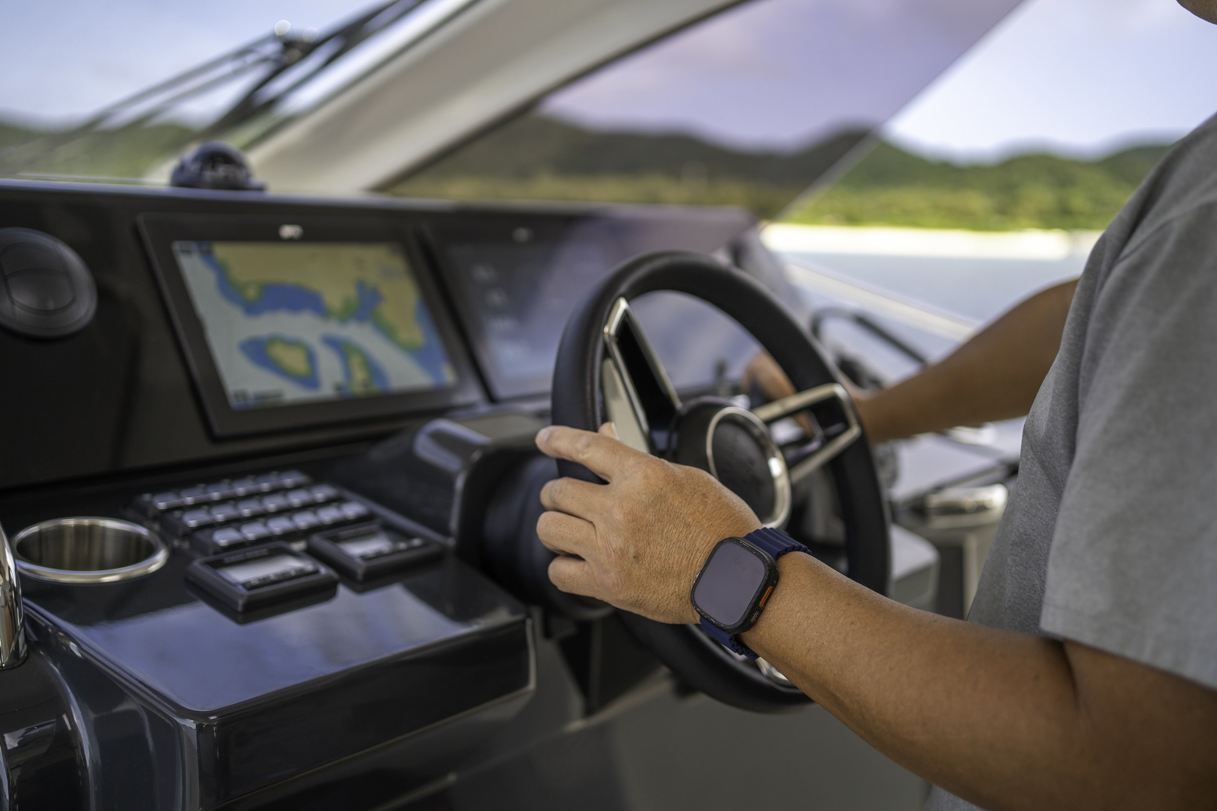 運転手が車のコックピットで航海用のデジタルナビゲーションを操作している。背景は自然の風景が見える。