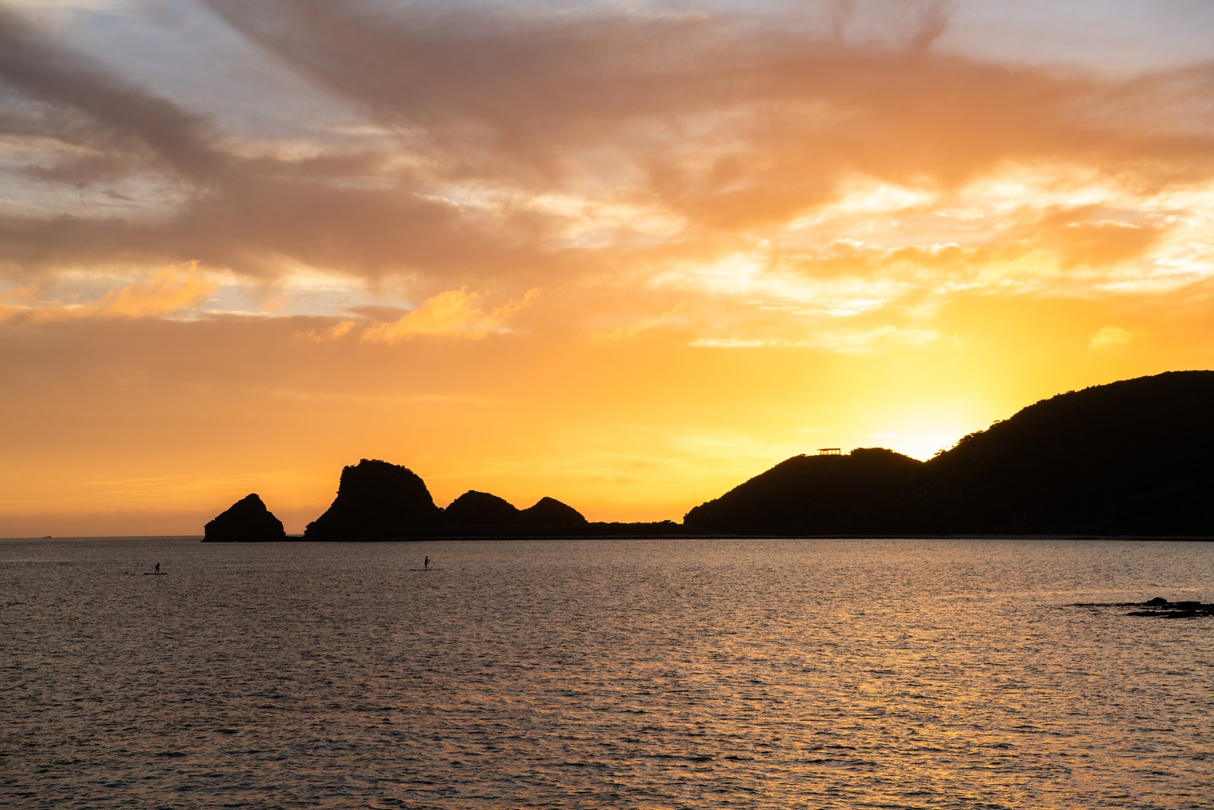 夕日が沈む海と島々のシルエット