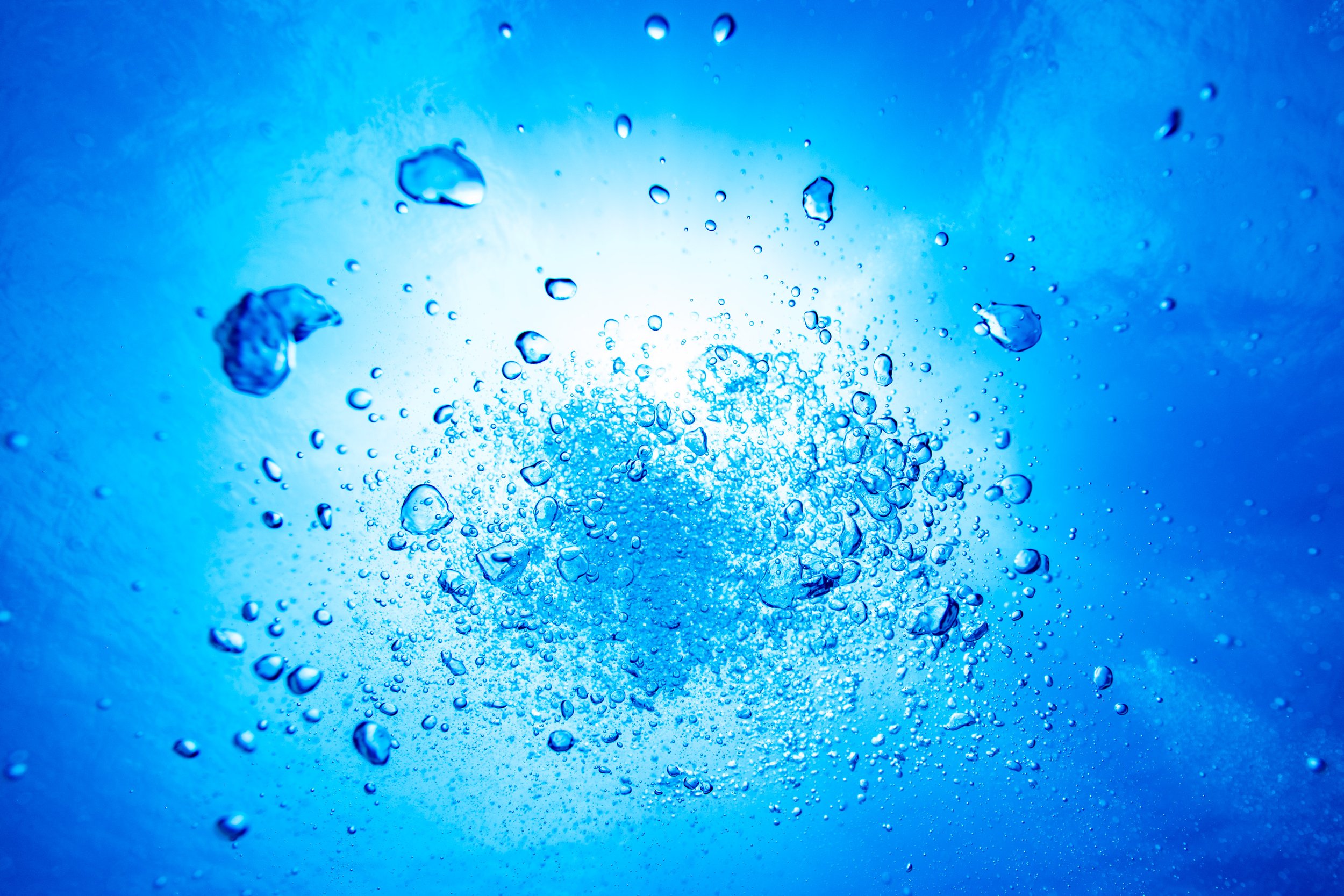 青い背景に泡立つ水の中の気泡のクローズアップ