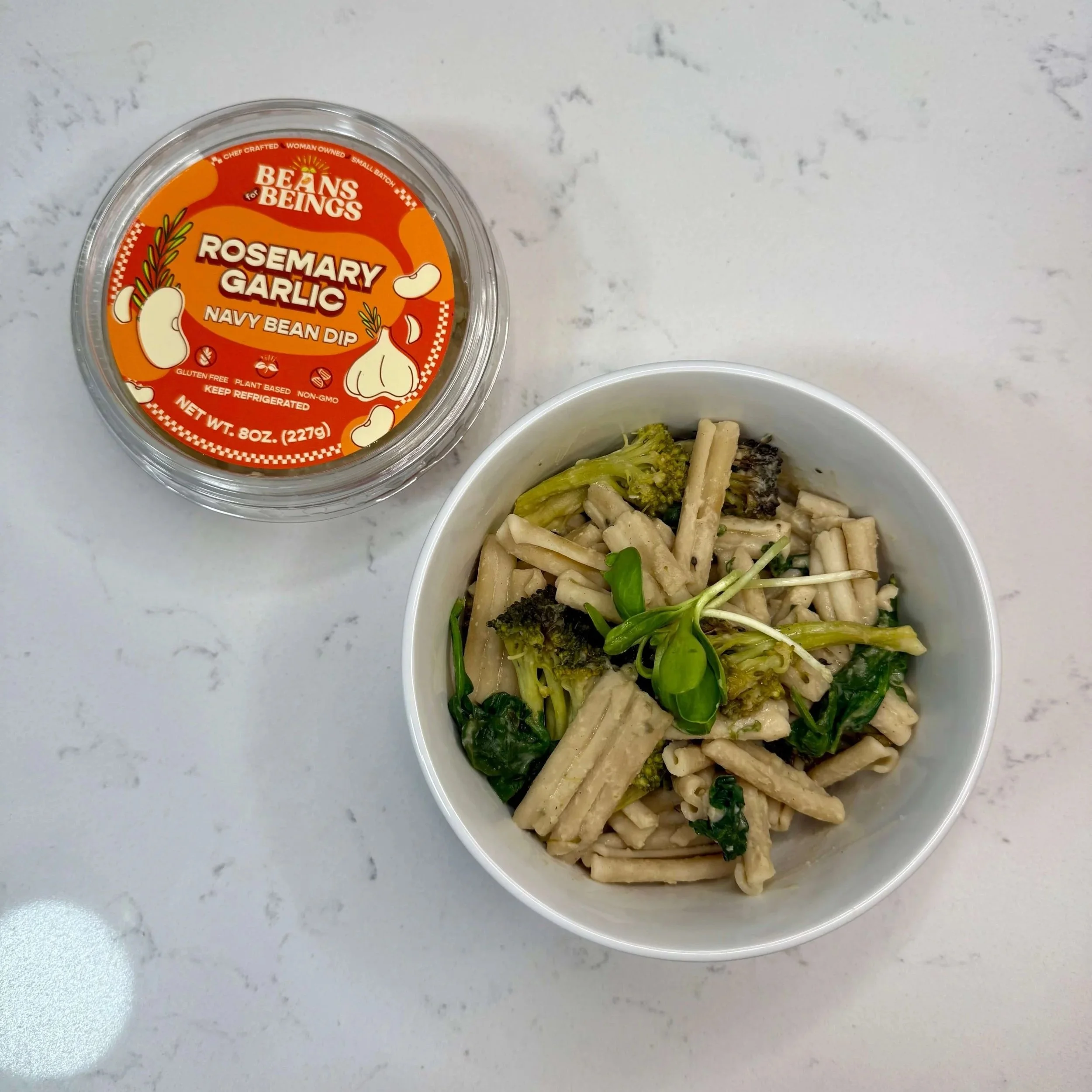 a bowl of pasta with a creamy rosemary garlic sauce from beans for beings