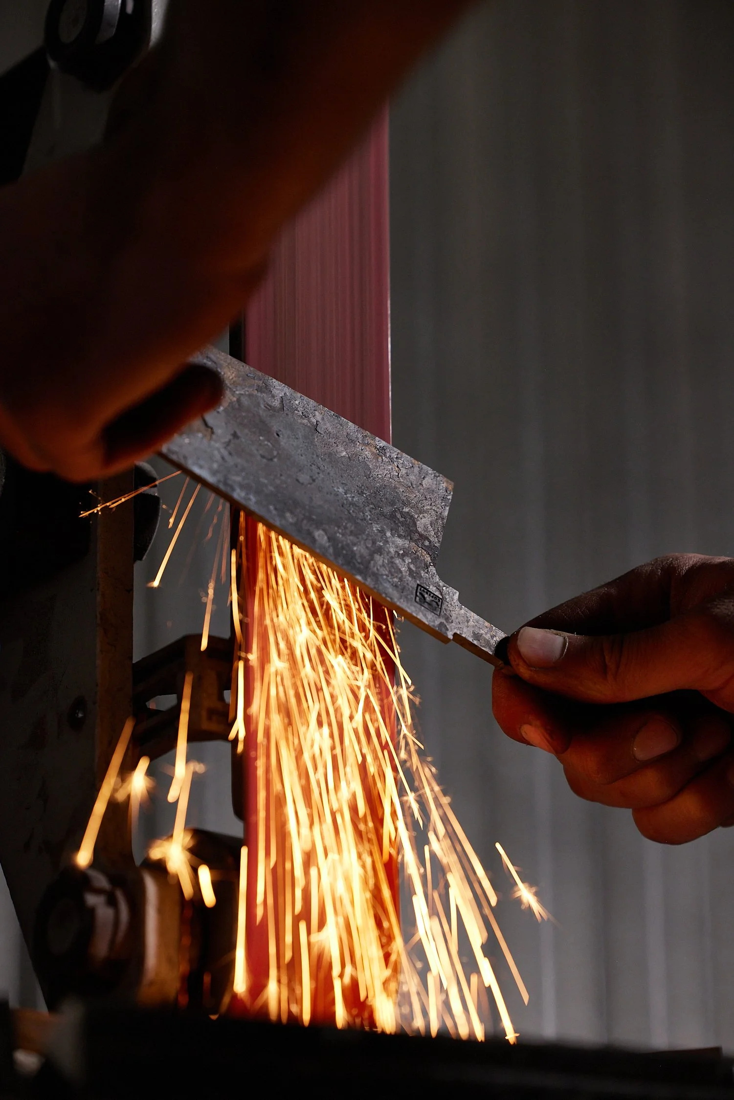 Close-up of sparks flying as someone uses a grinder on a piece of metal.