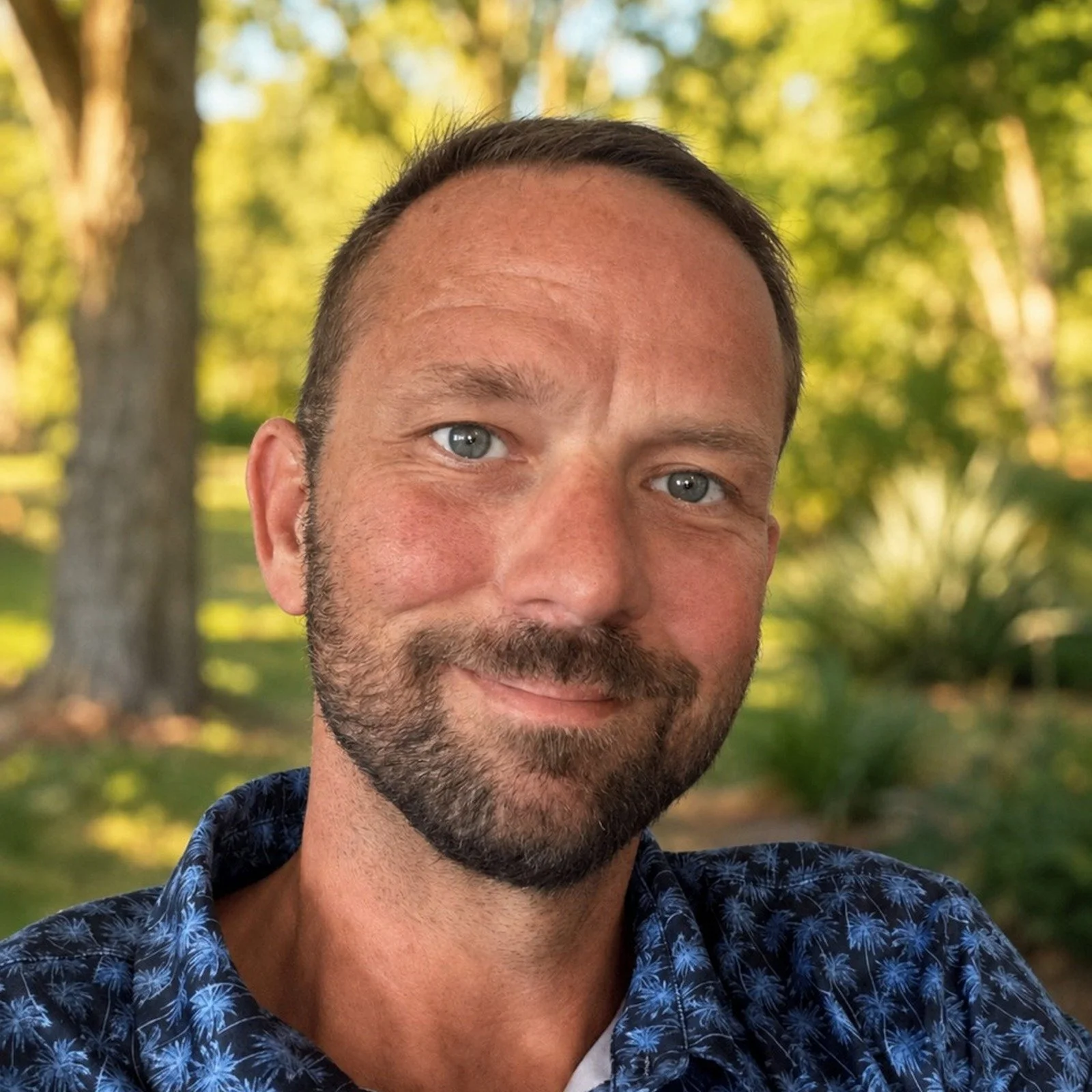 Portrait of Lee Holt outdoors with trees in the background.