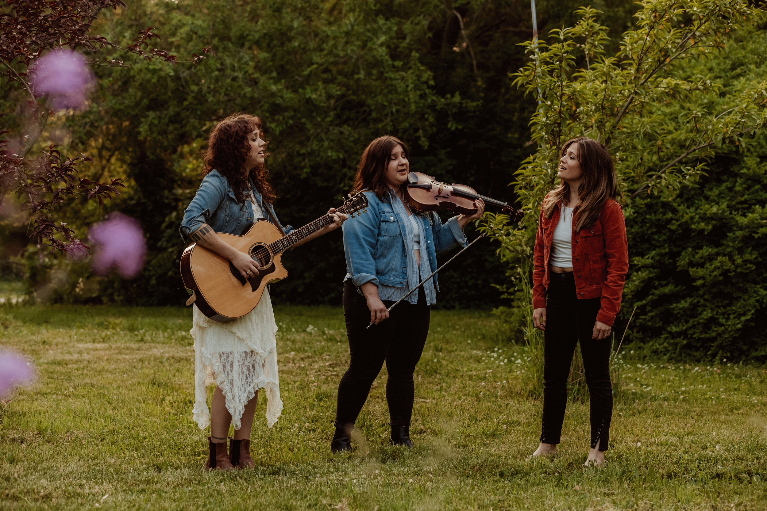 Three girls singing and playing instruments