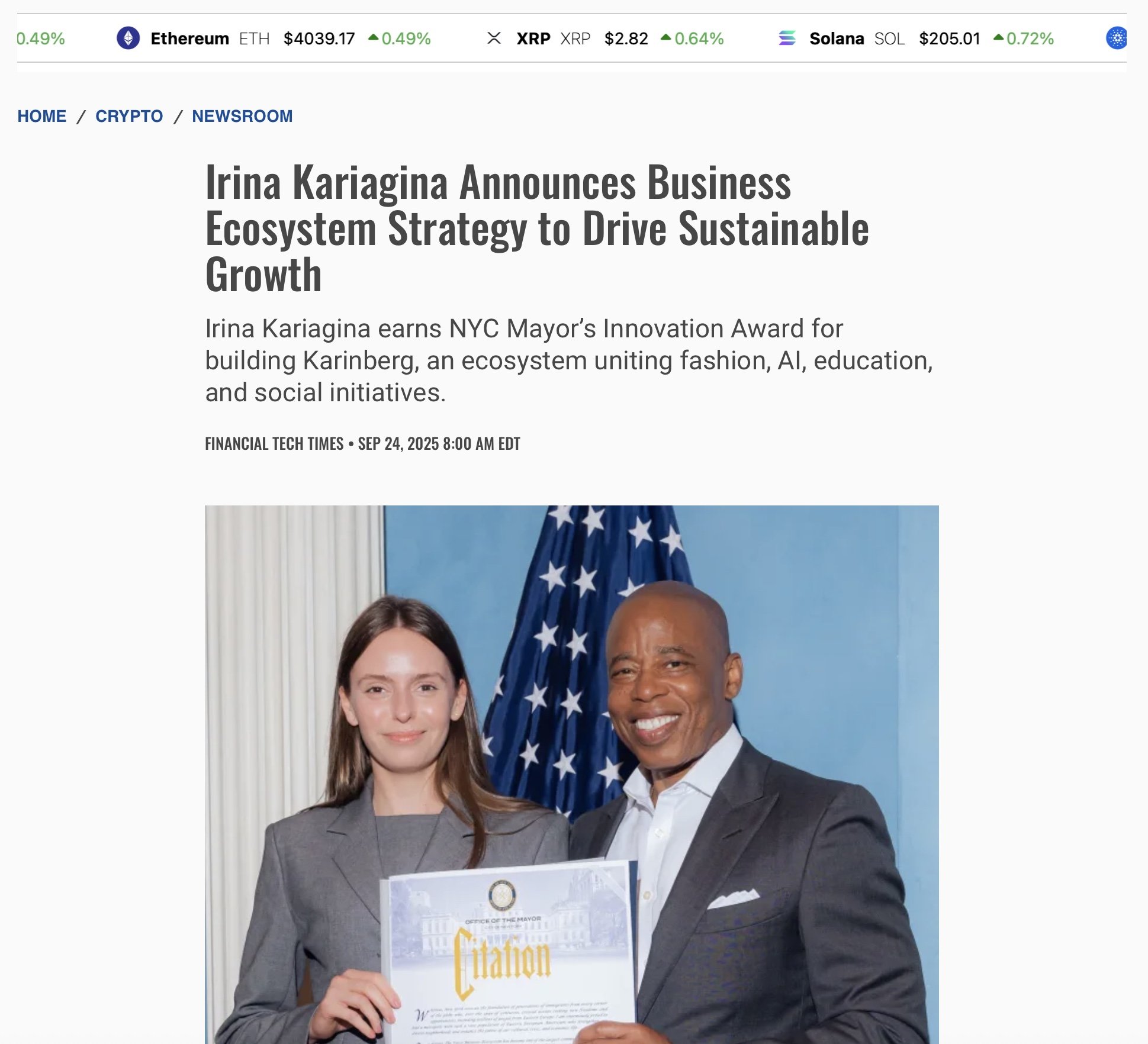 Irina Kariagina and a man in suits holding a citation with an American flag in the background.