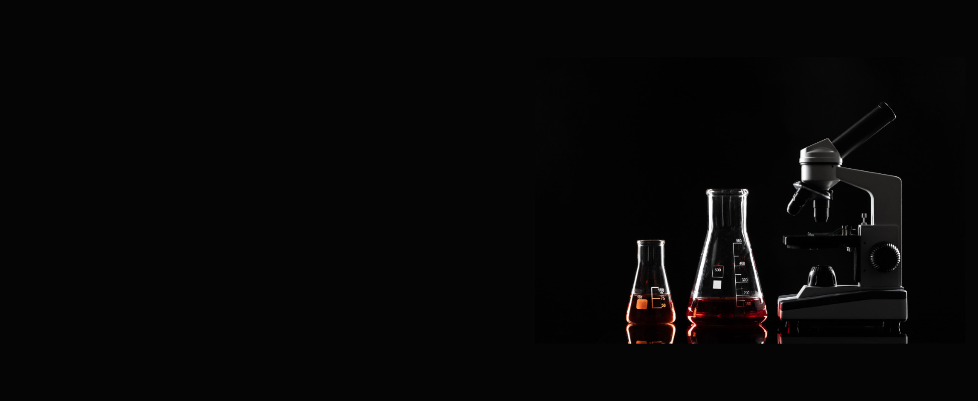 Laboratory scene with a black background, featuring three glass vials containing red liquids and a microscope.