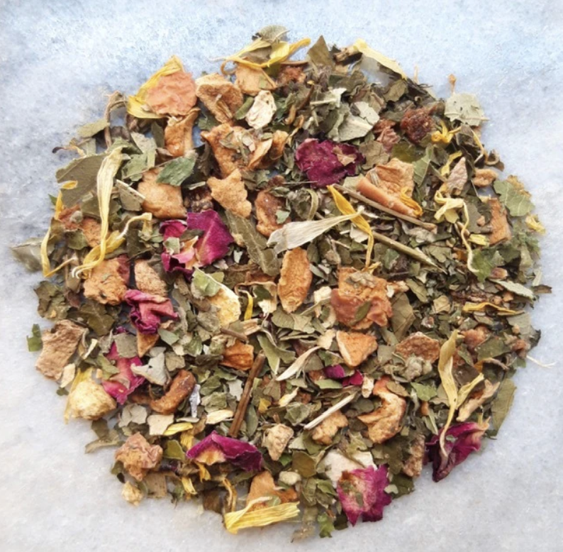 A mixture of dried herbal leaves, flower petals, and small chunks of dried fruit or herbs.