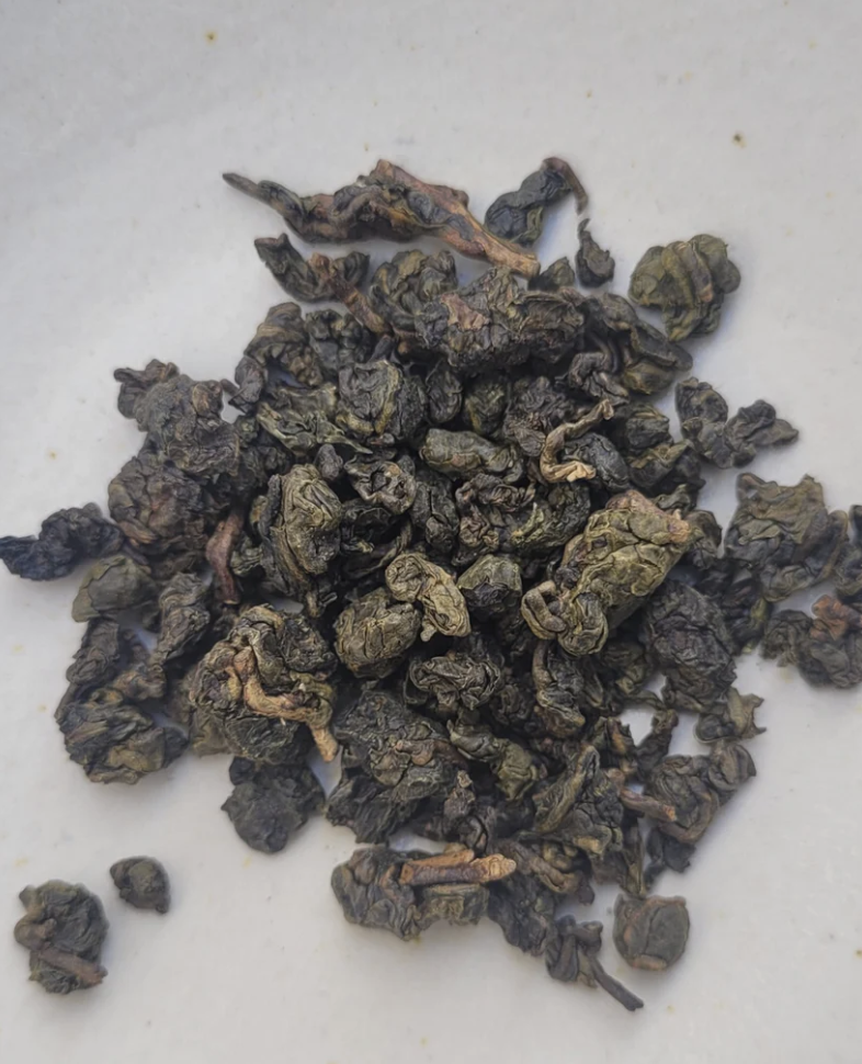 Dried tea leaves on a white surface.