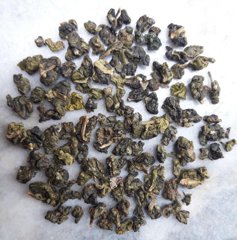 Dried oolong tea leaves scattered on a light surface