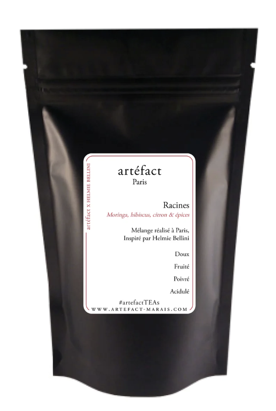 Black resealable pouch with a white label that reads 'artefact Paris Racines' and describes a tea blend made with herbs such as moringa, hibiscus, lemon, and spices.