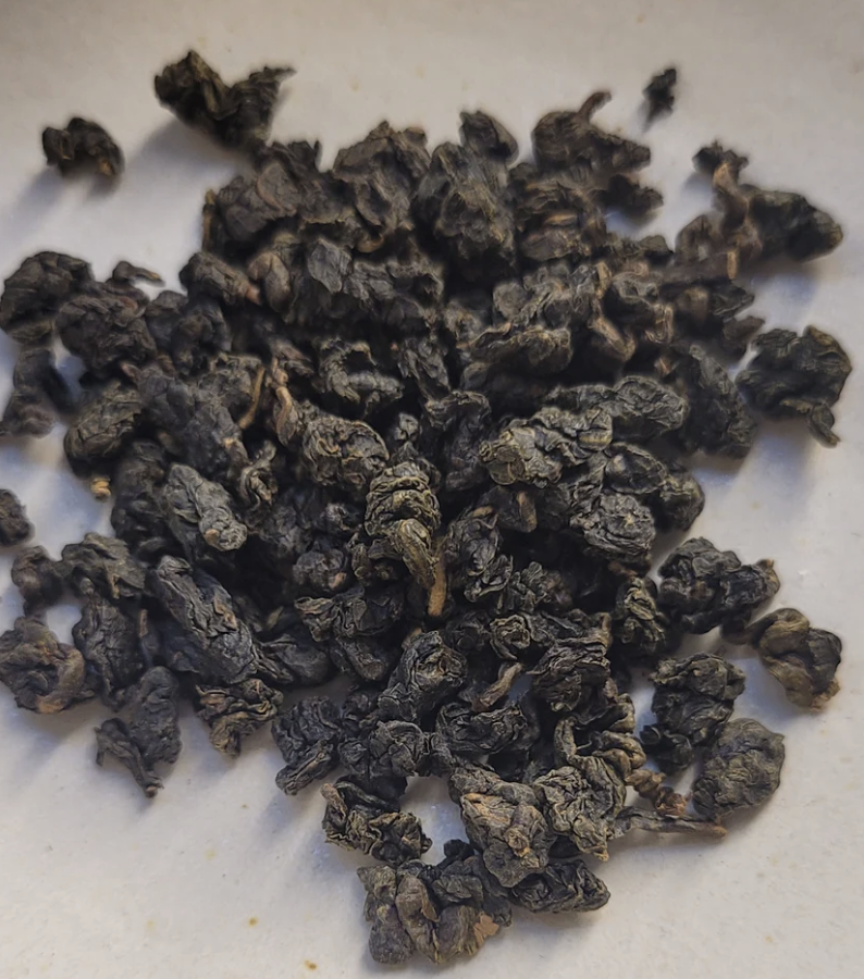 Dried purple tea leaves on a white surface