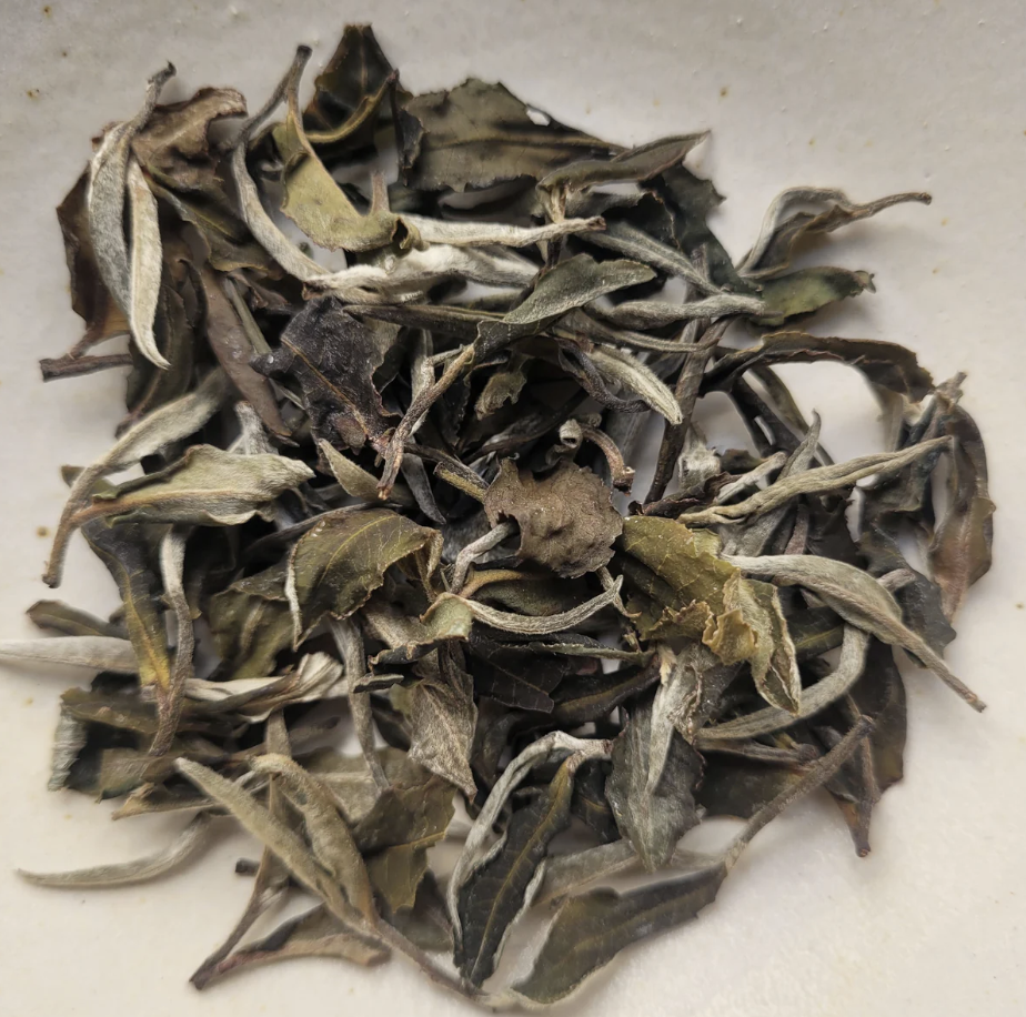 Dried tea leaves on a white surface.