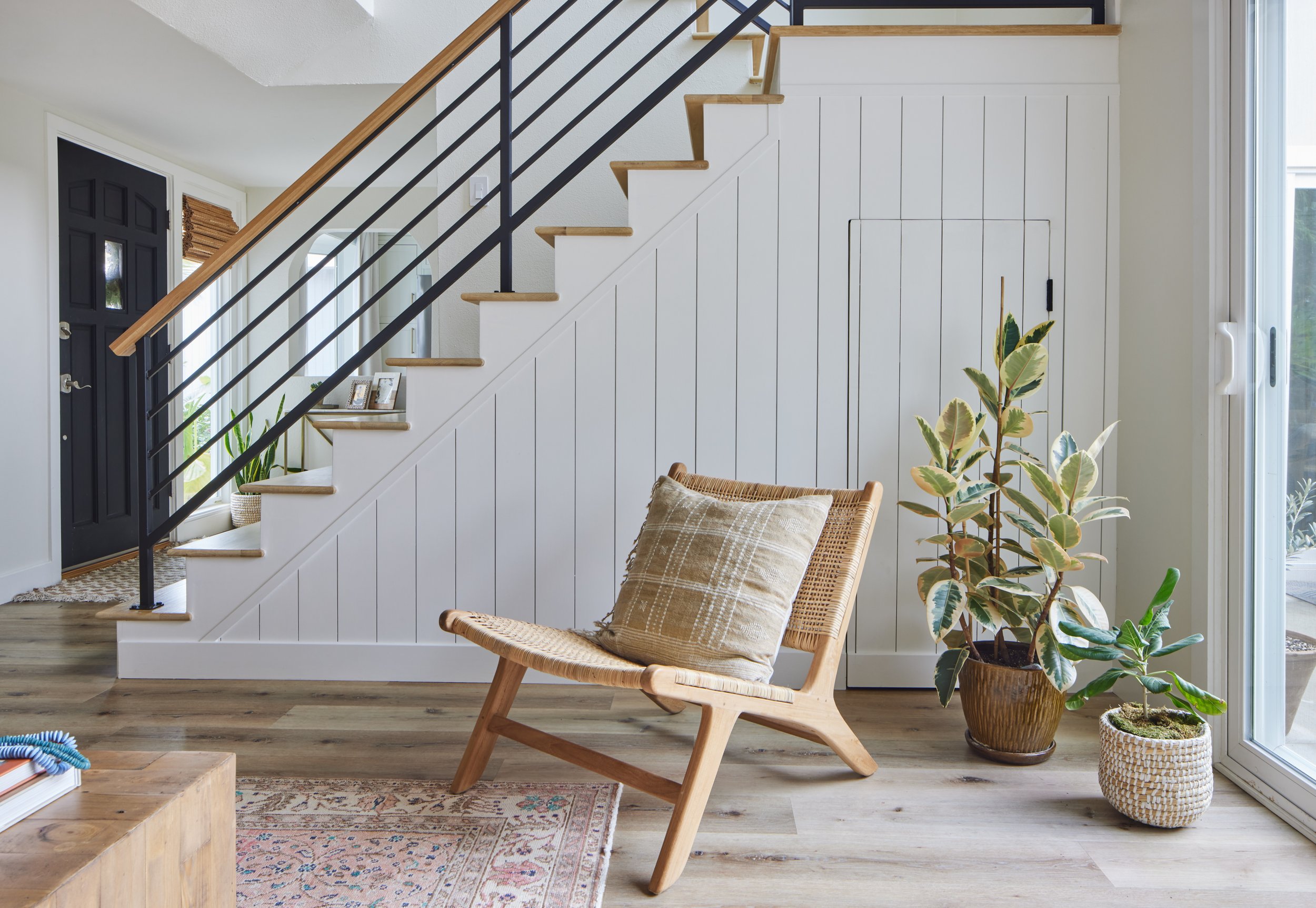 thoughtfully designed sitting area with shiplap wall, staircase railing, and accent chair in a Southern California family home