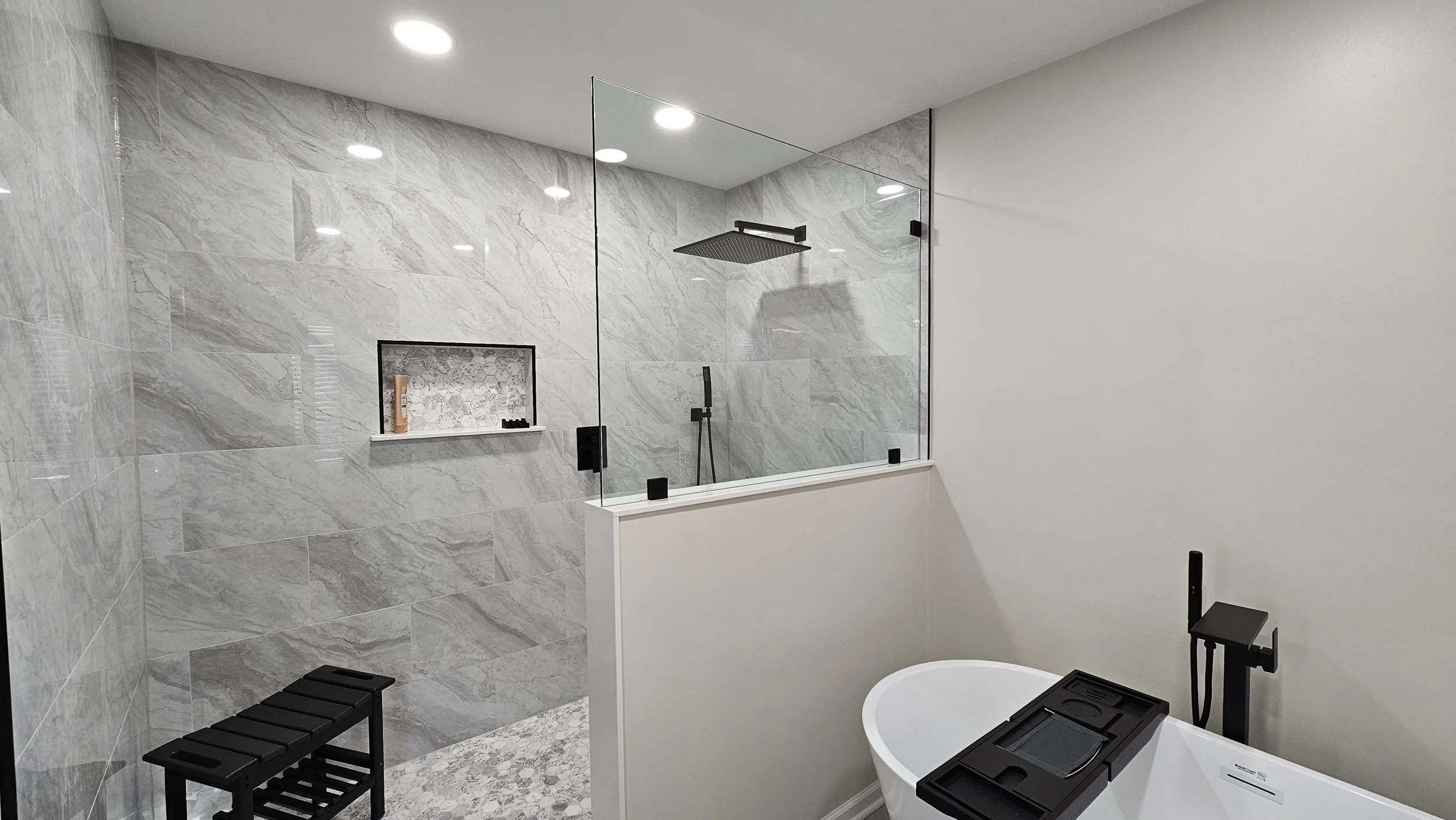 Master bathroom remodel in Algonquin featuring an oversized walk-in shower with marble mosaic floor tiles, gray porcelain wall tiles, and a freestanding tub.