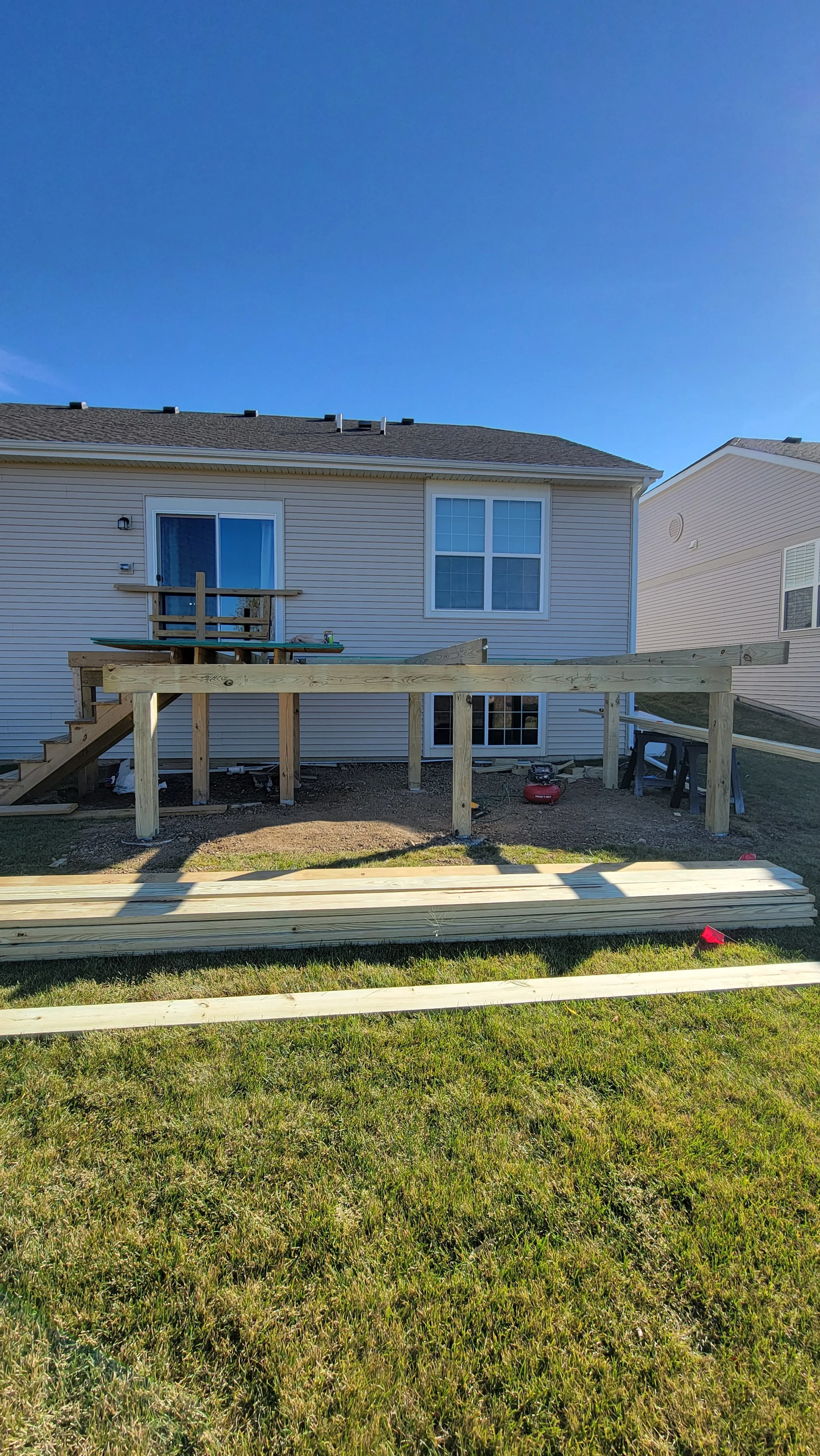 Framing process of a deck addition in Huntley, showing the wooden framework being constructed to create the new deck structure.
