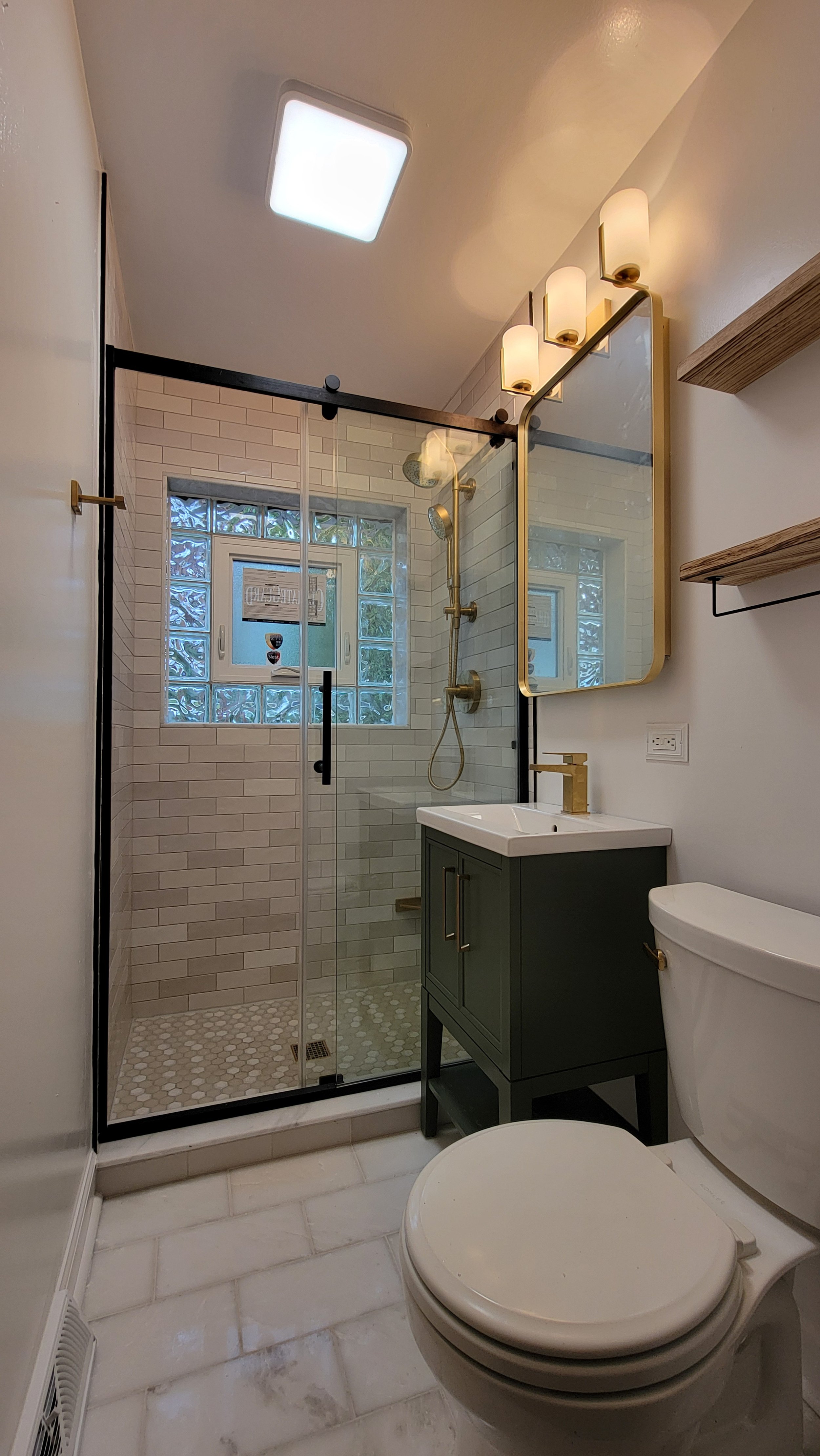 Contemporary guest bathroom in Mount Prospect featuring a new walk-in shower, multicolor subway tiles, marble tile flooring, and high-end Kohler fixtures.