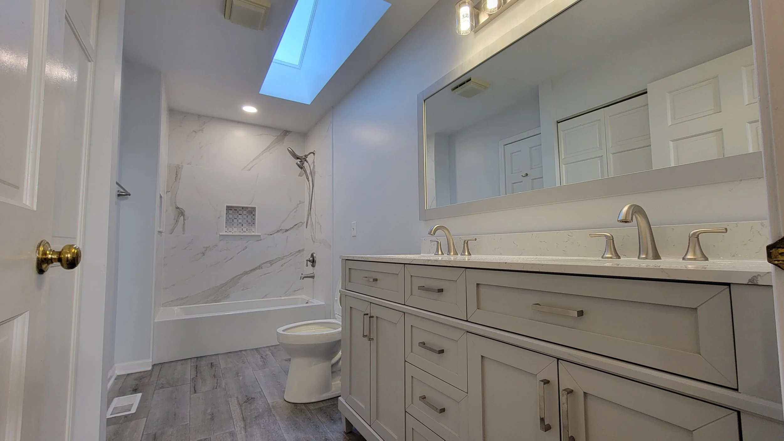 Guest bathroom remodel in Barrington featuring large format luxury tiles, modern fixtures, and a modern double sink vanity