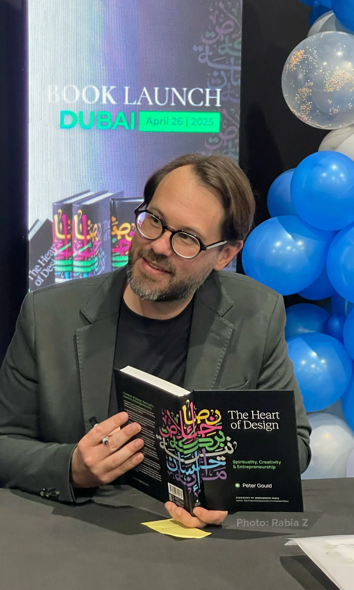 A photograp of Peter Gould holding a copy of his new book, The Heart of Design at his book launch in Dubai. Photo credit: Rabia Z.