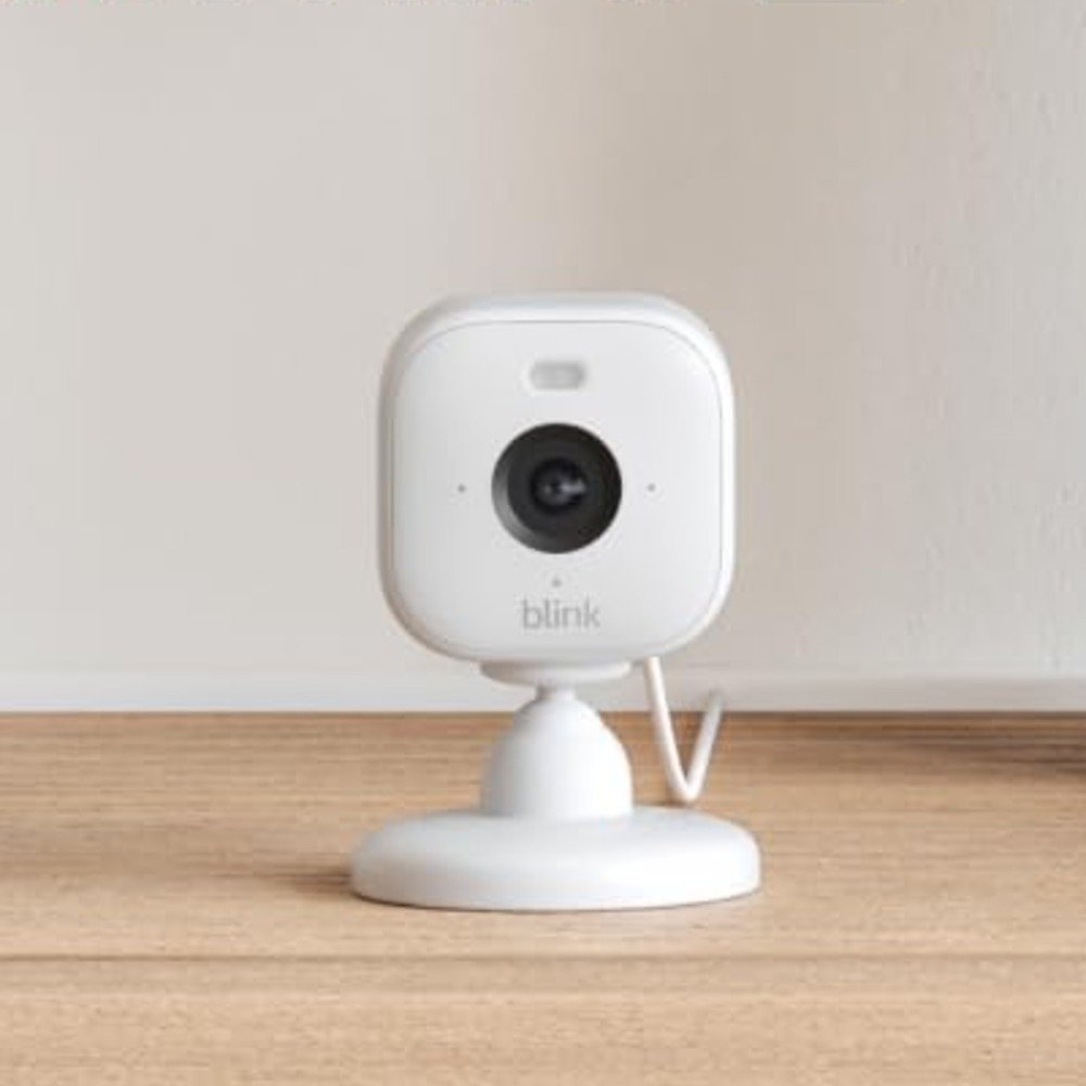 White Blink Mini 2 indoor security camera on a wooden surface