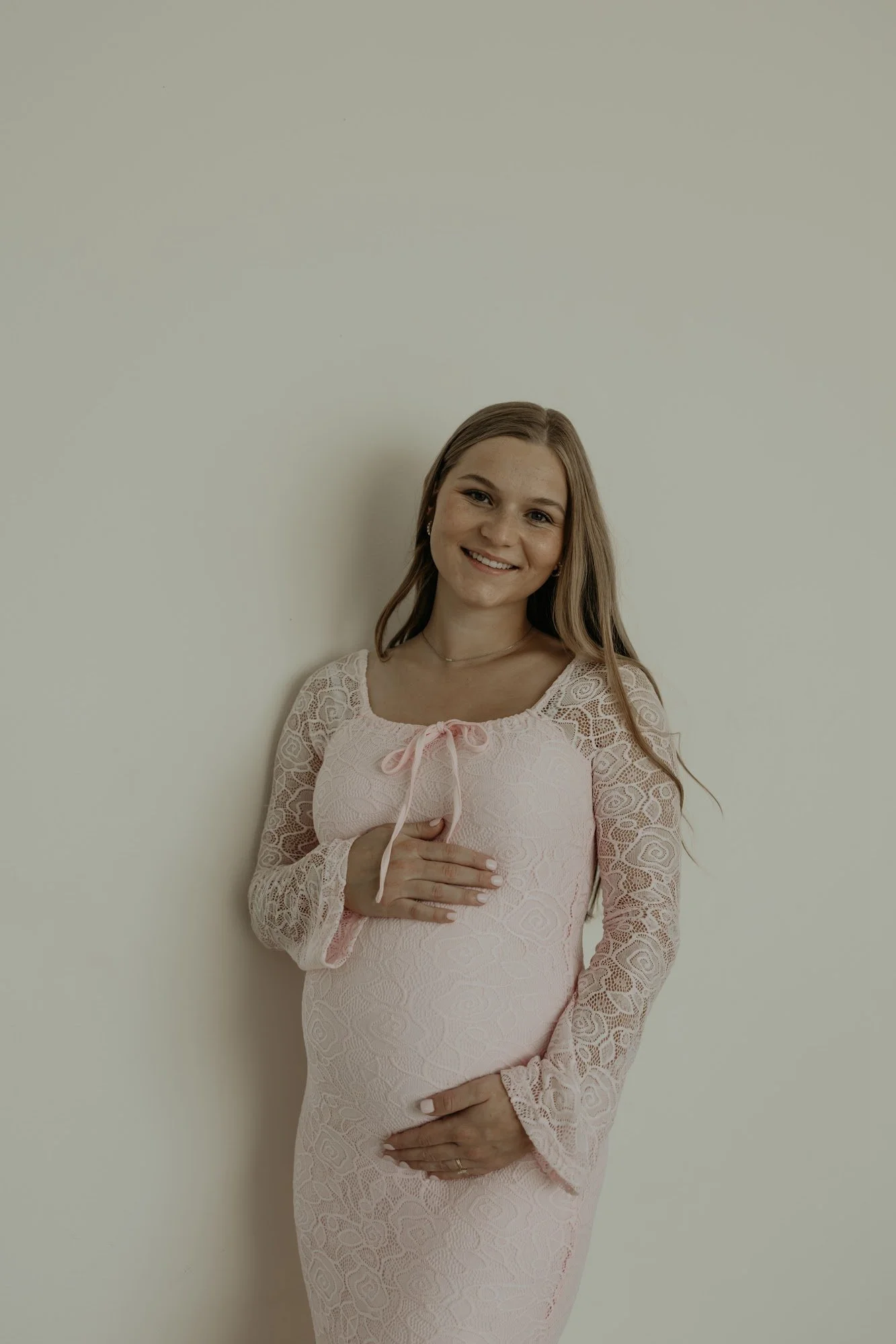 Charleigh, this week's Recommender, smiling in a pink lace maternity dress