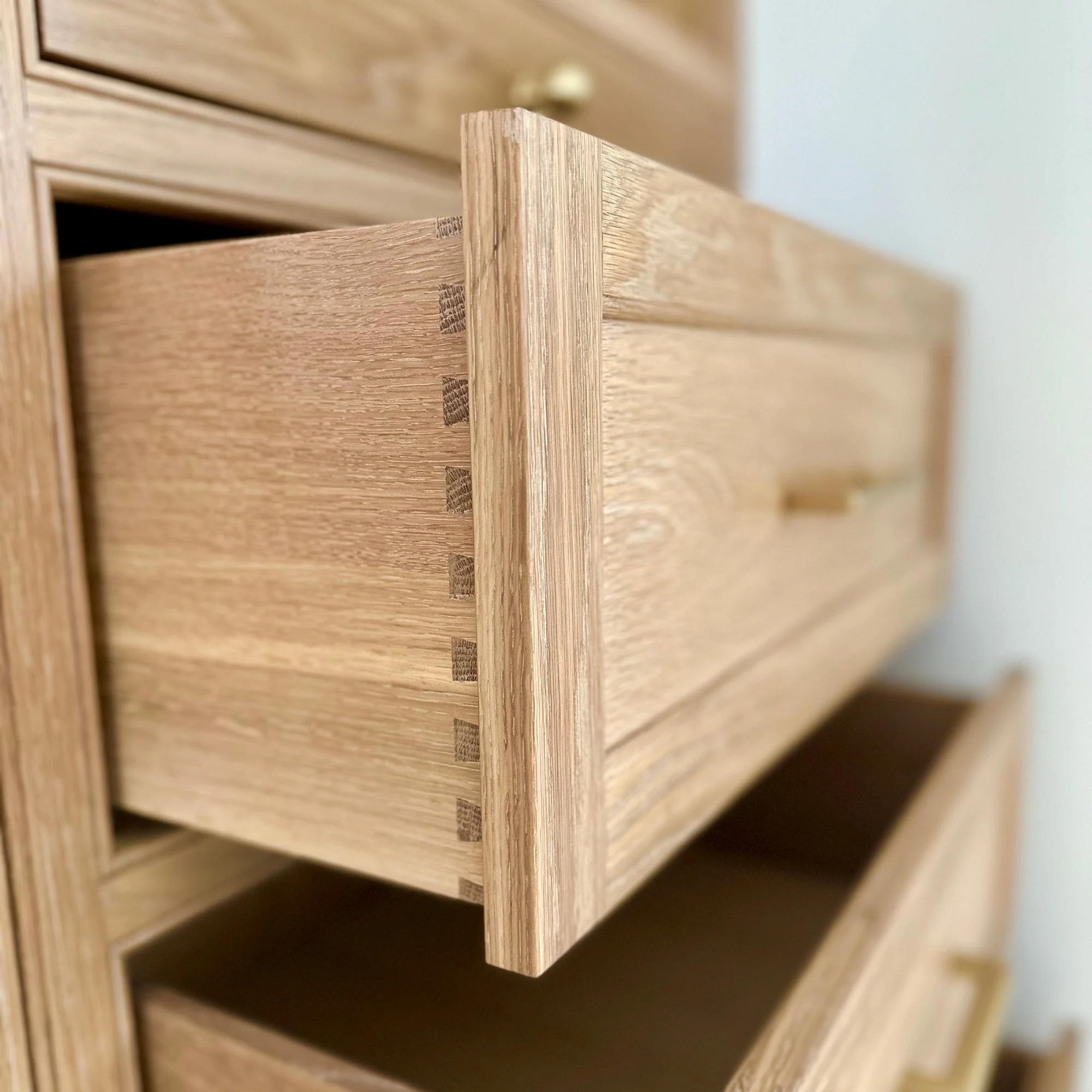 Drawer boxes | Custom white oak bedroom armoires designed to expand closet storage in a Newburyport, Massachusetts home.