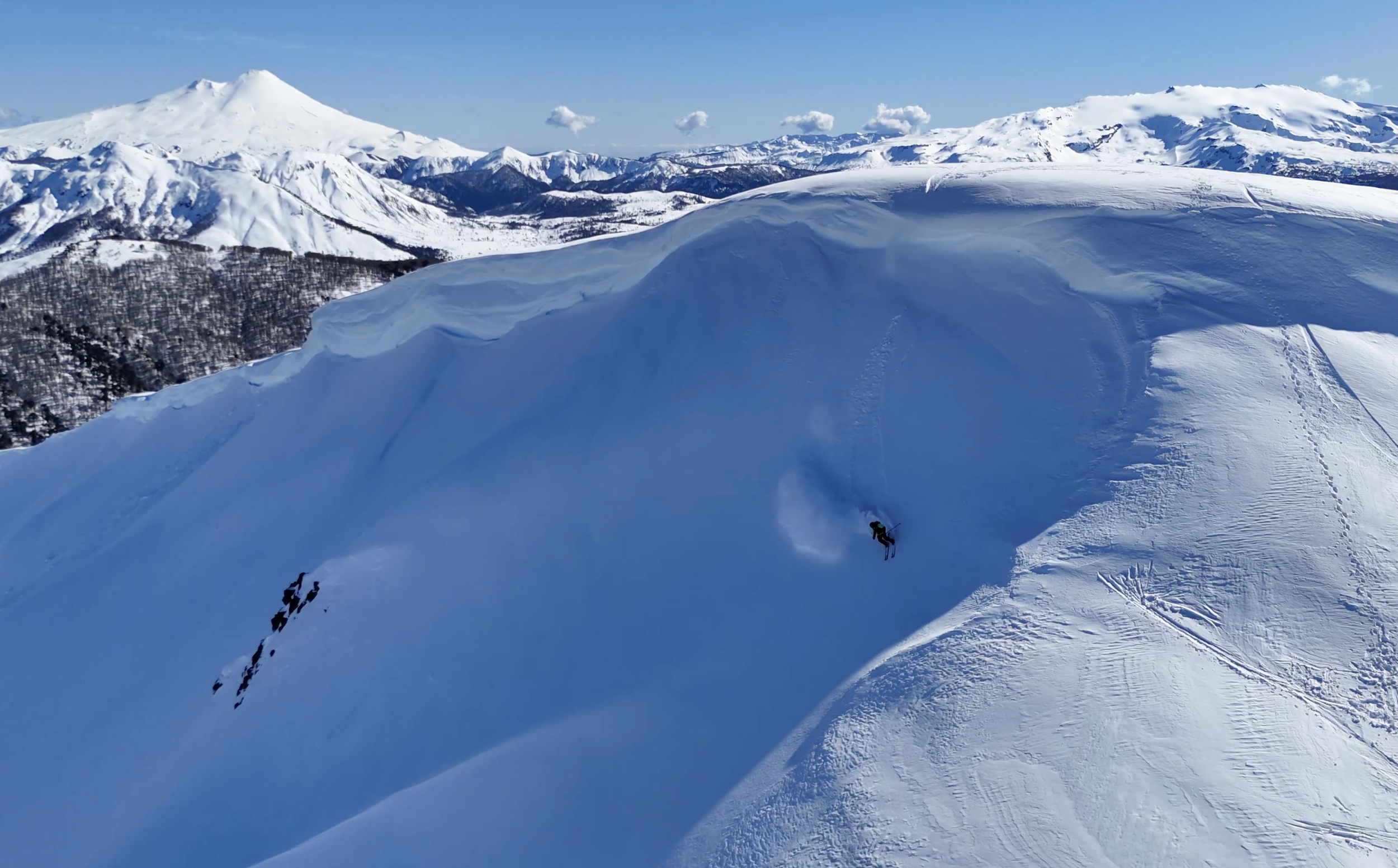 Backcountry randonee skier in Chile jumping a cornice.