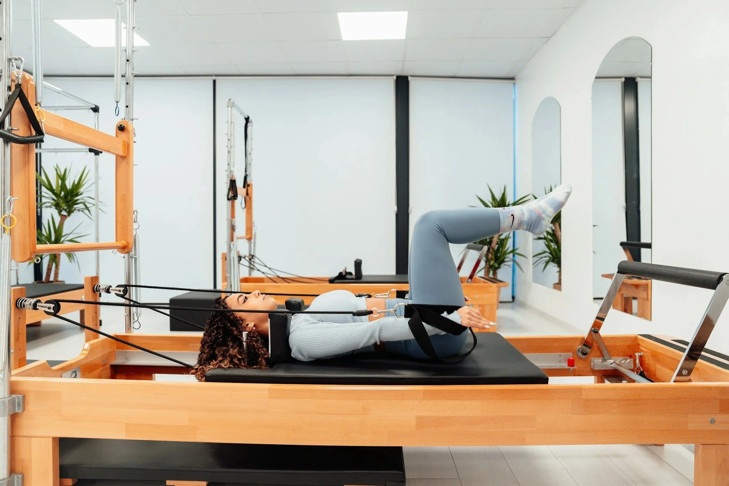 A woman on a pilates reformer machine.