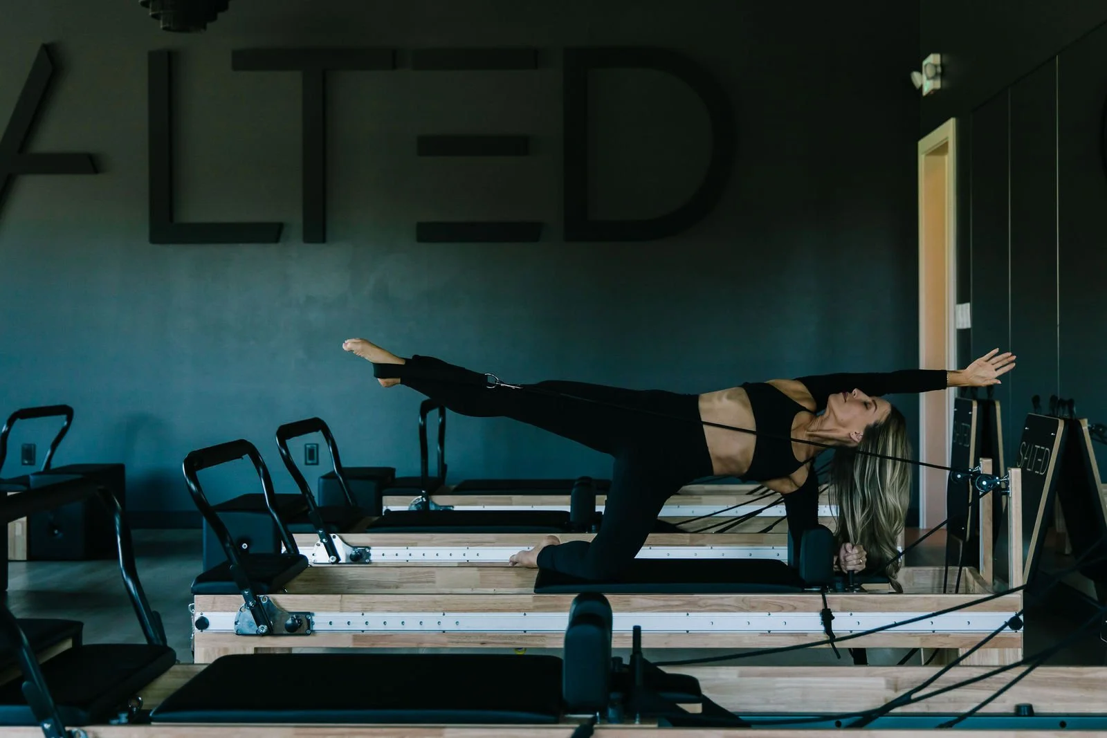 Reformer Pilates class in front of the SALTED wall