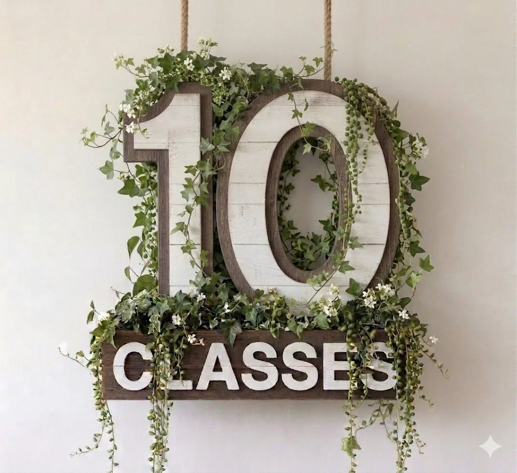 Decorative sign with large wooden numbers '10' and the word 'classes' below, surrounded by greenery and small white flowers.