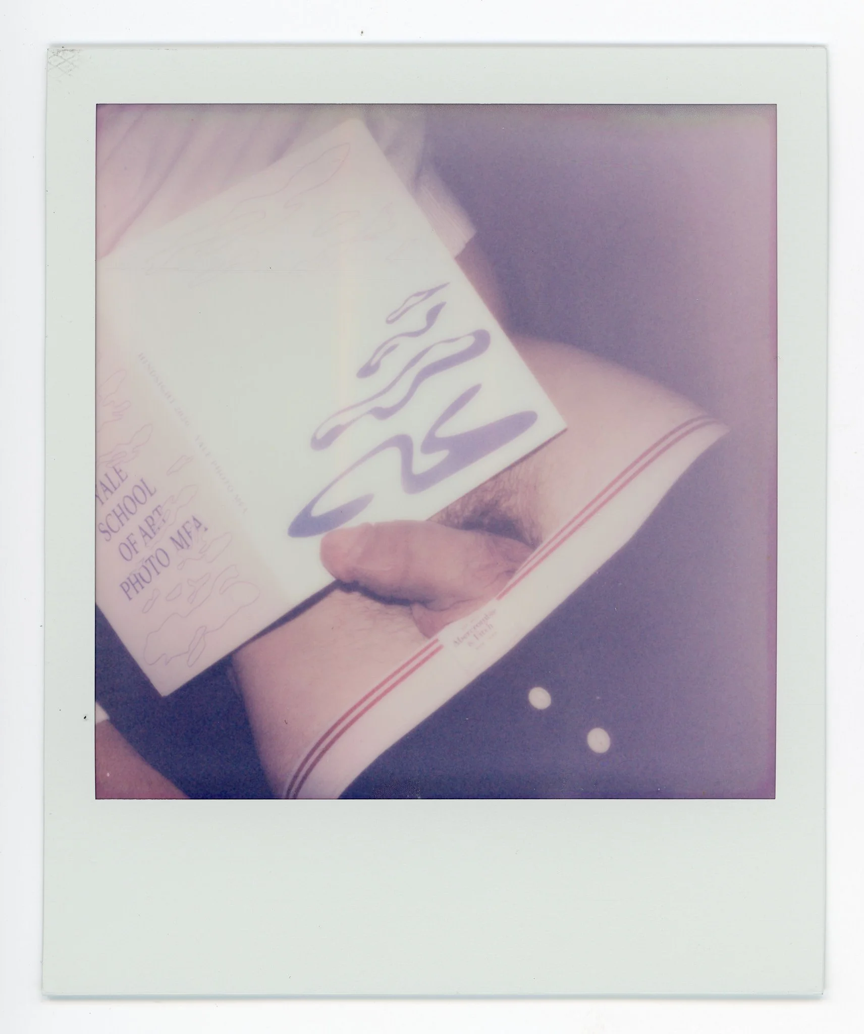 A person is holding a booklet that reads 'SASA' and is wearing striped underwear with a red lining. The person is also wearing dark clothing with two white buttons.