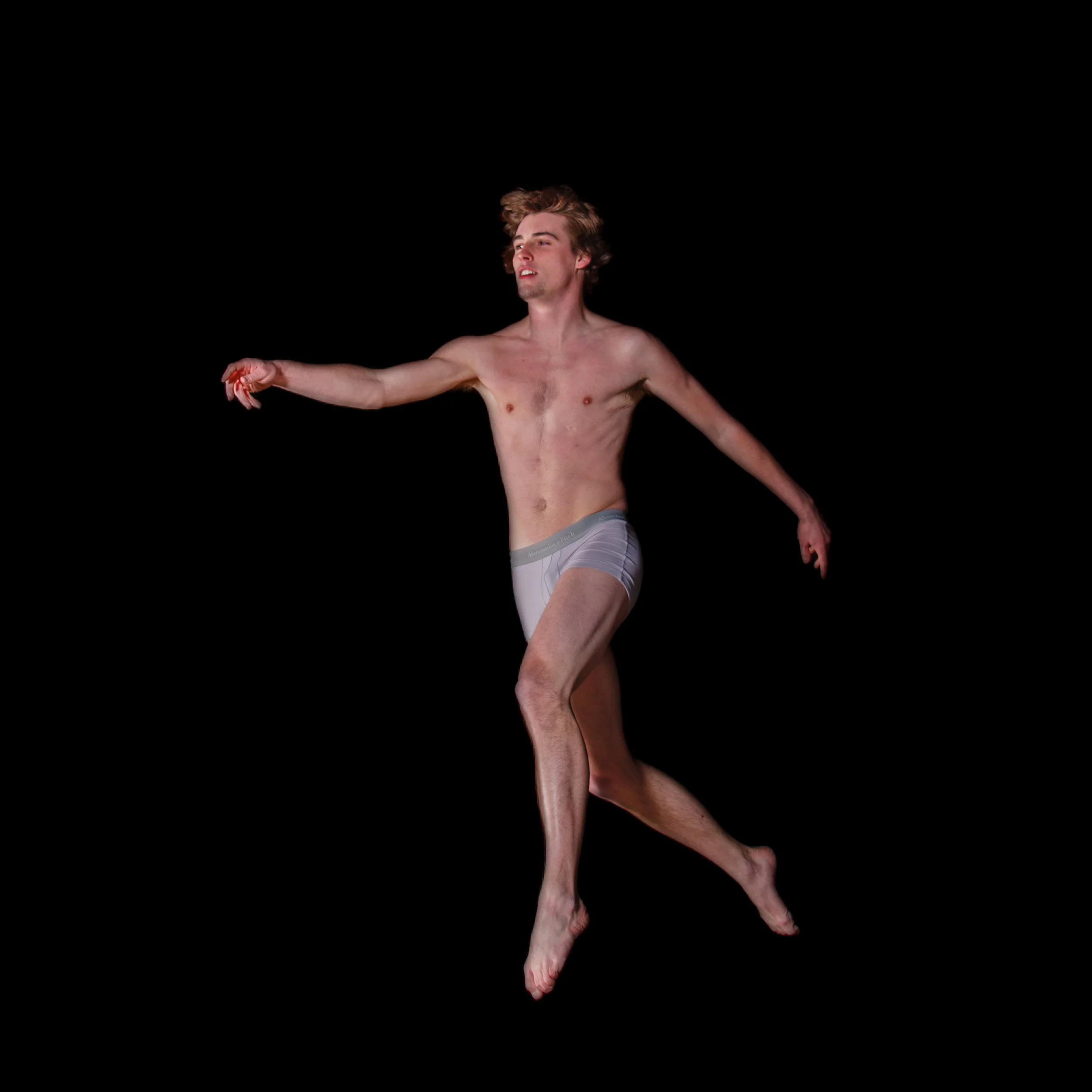 A shirtless young man with light skin, wearing gray underwear, is floating in a black void, with one arm extended outward and the other relaxed at his side, with a neutral expression on his face.