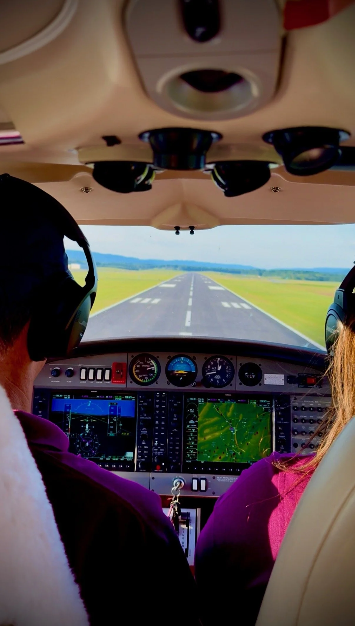 Airplane cockpit with flight instructors landing on a runway. 