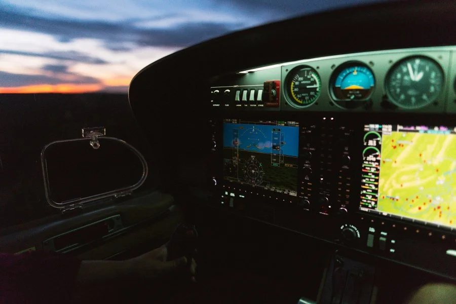 Female flight instructor standing inside a hangar near aircraft discussing flight training and rudder control. 