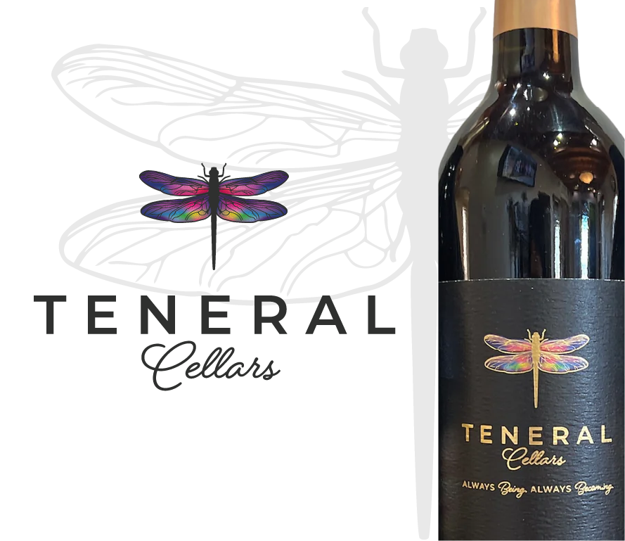 A dark-colored wine bottle with a black label featuring a colorful dragonfly and gold text reading 'Teneral Cellars' and 'Always Being, Always Becoming.'