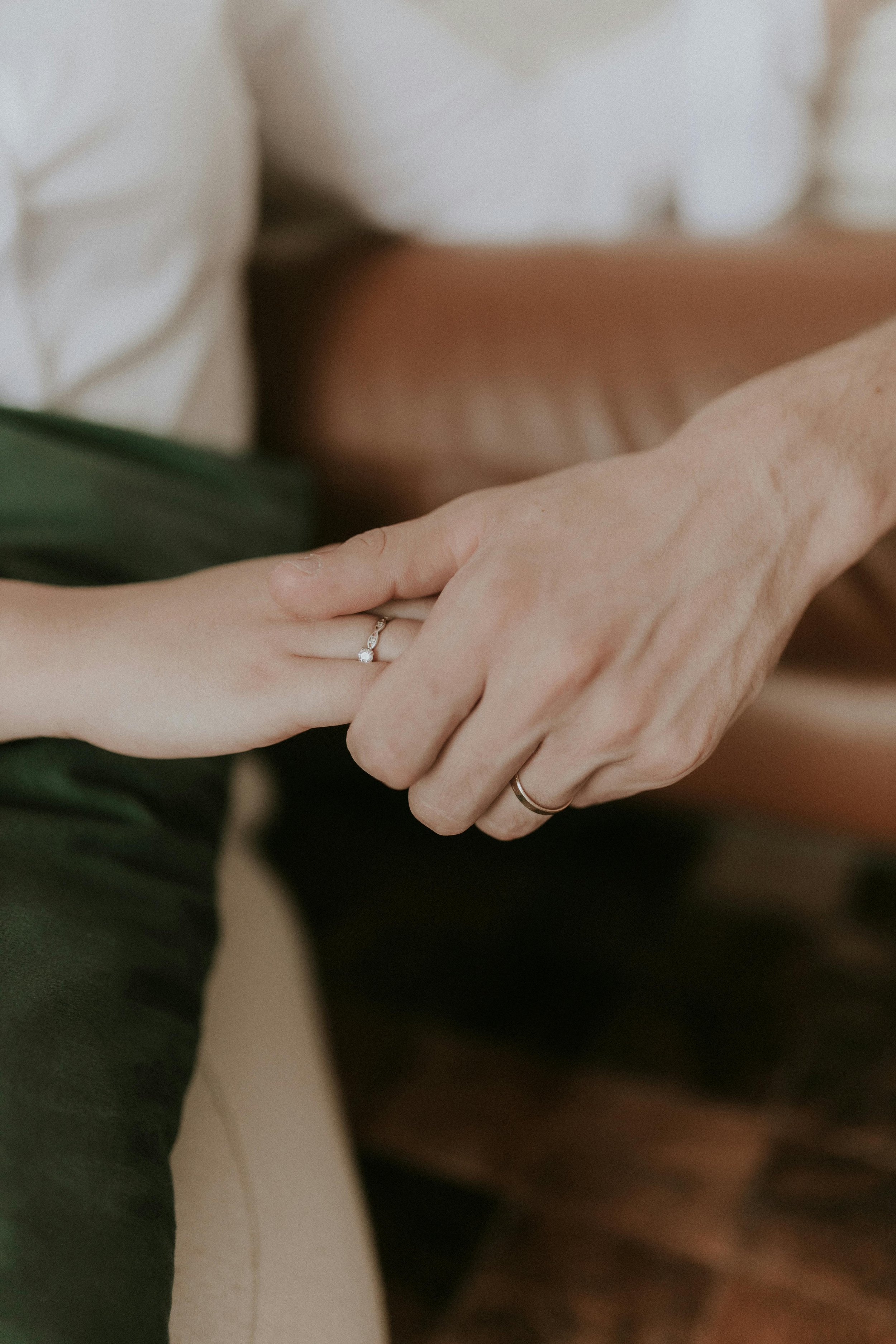 Two people holding hands with wedding rings, symbolizing partnership and commitment amidst relationship challenges
