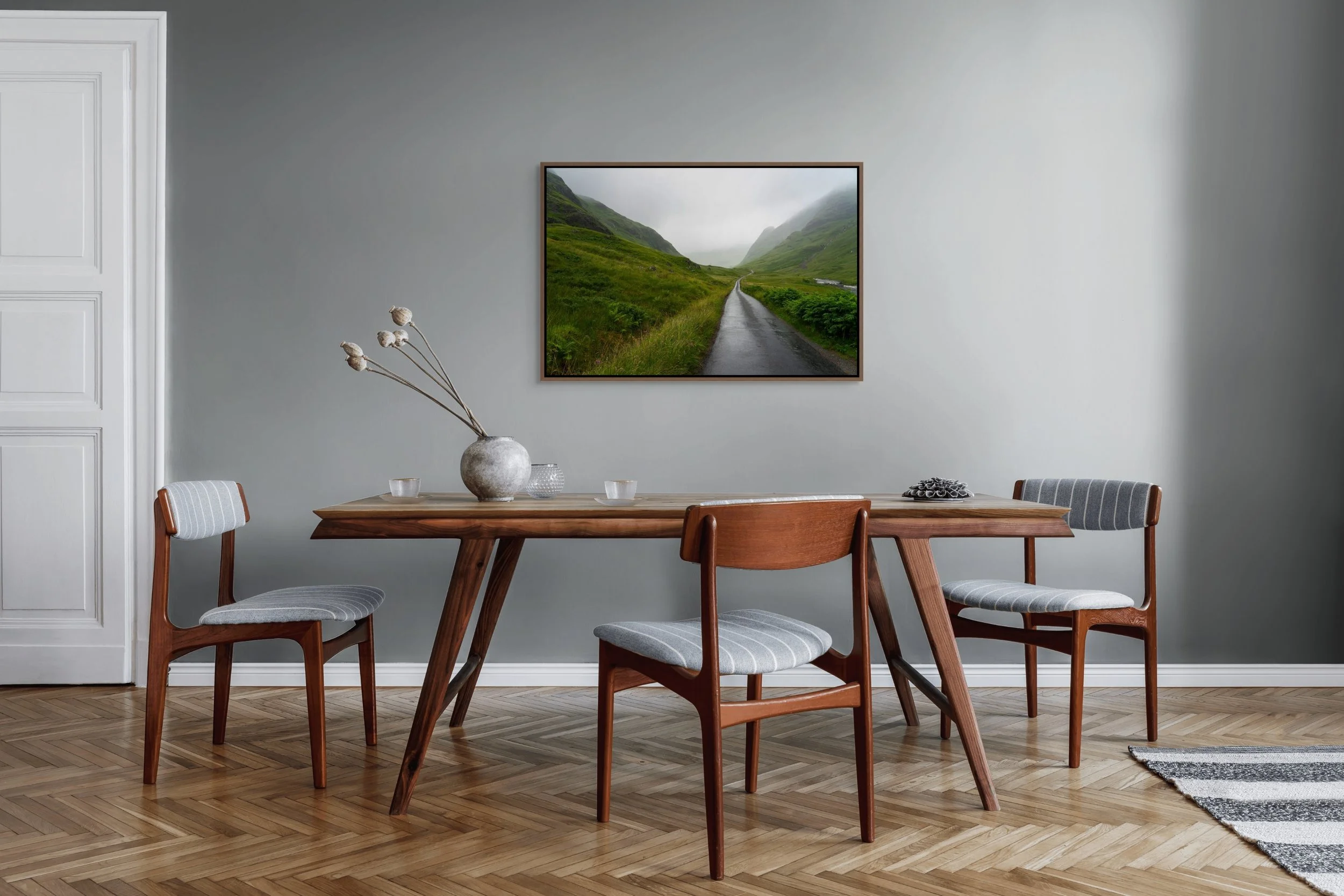 Into the Mist, framed in a walnut floating frame, shown above a mid-century dining table and chairs against a soft grey wall.