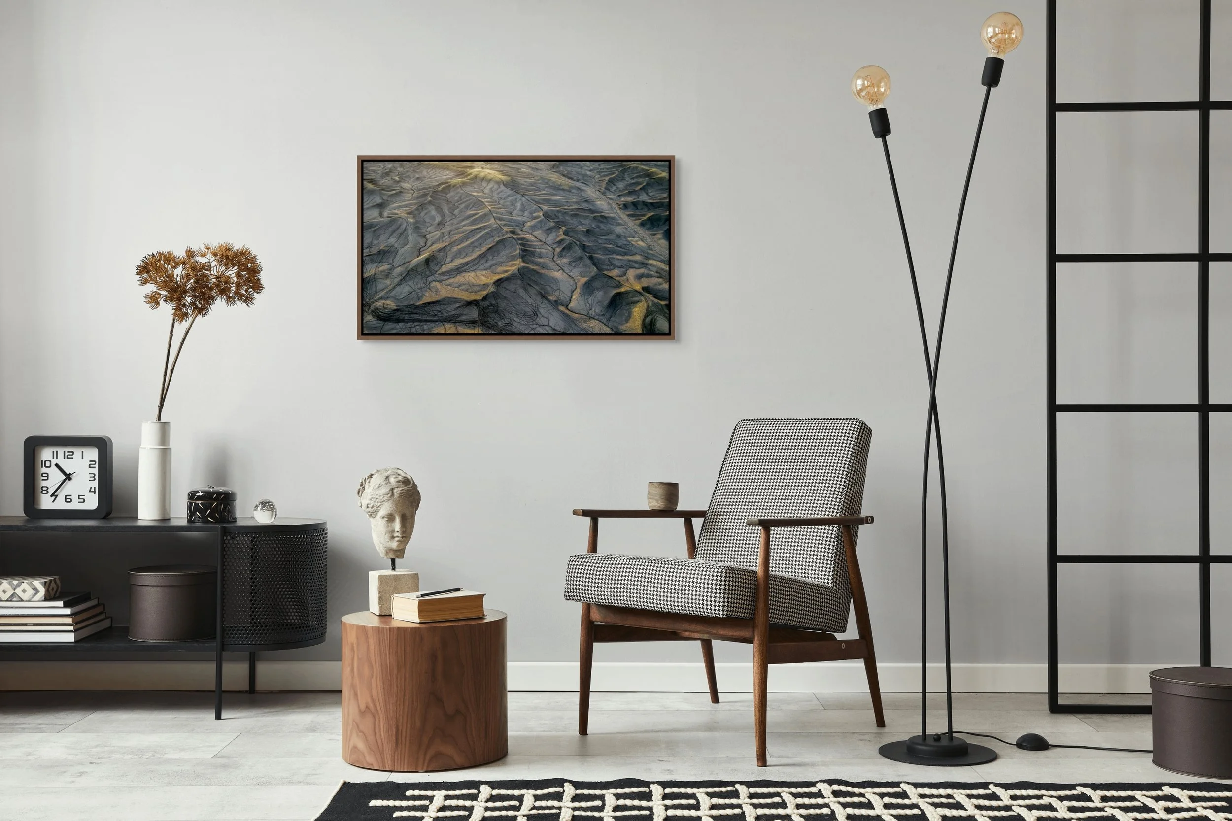 Erosion Lines in a floating walnut frame, shown with modern furnishings, ladder shelf, and patterned rug.
