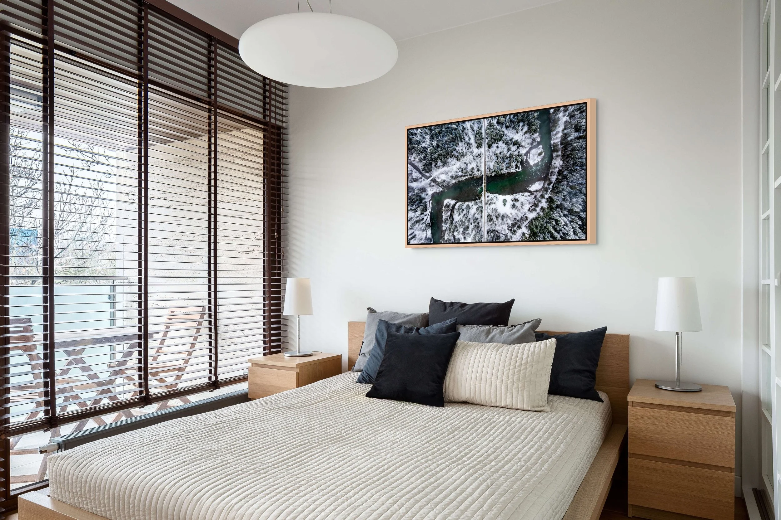 The Hidden Crossing, framed in Natural Oak floating frame, above a calm bedroom with large window and sheer blinds.