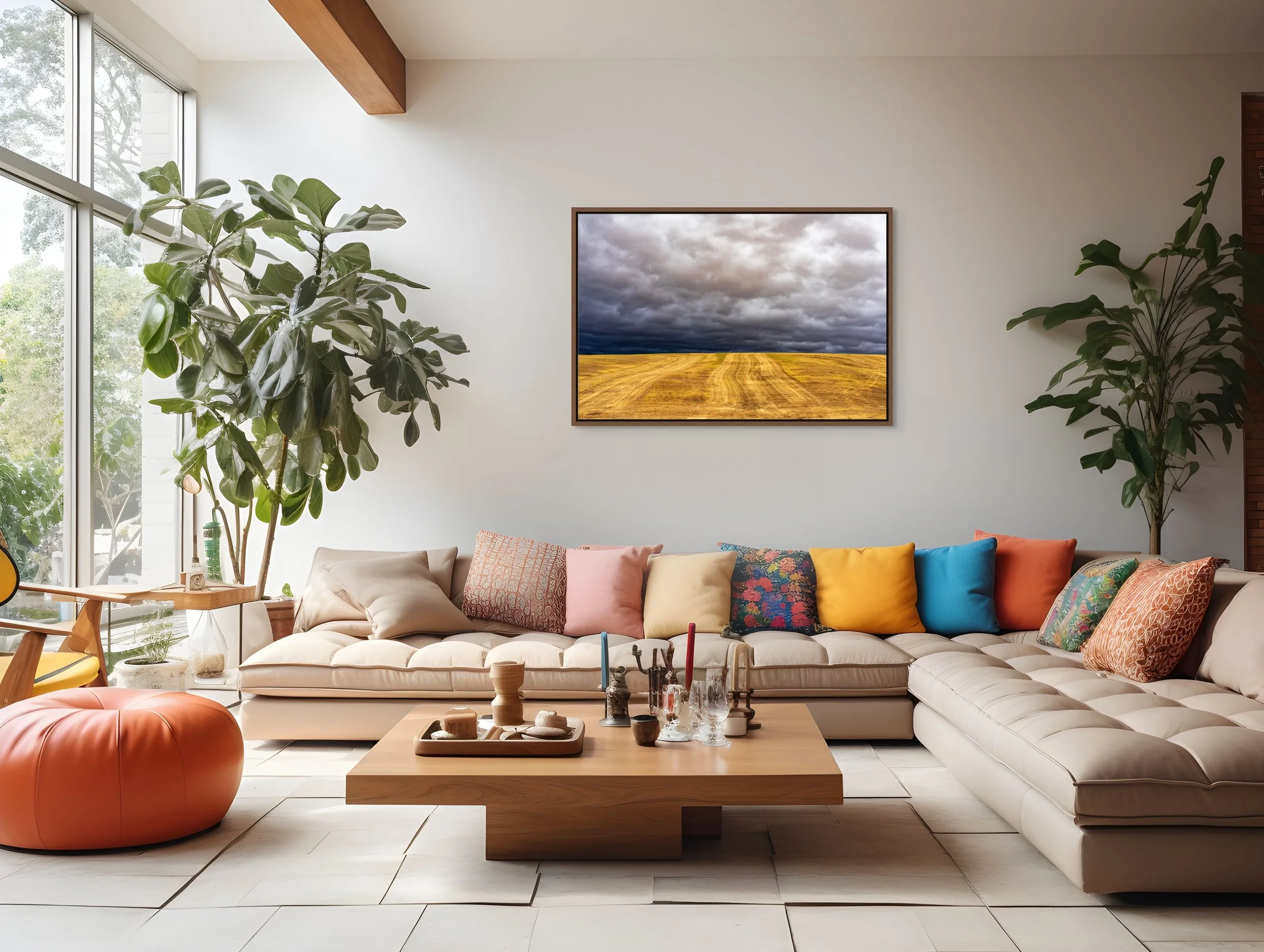 Before the Storm in a floating Walnut frame, styled in an airy living room with tan sofa, colorful cushions, and plants.