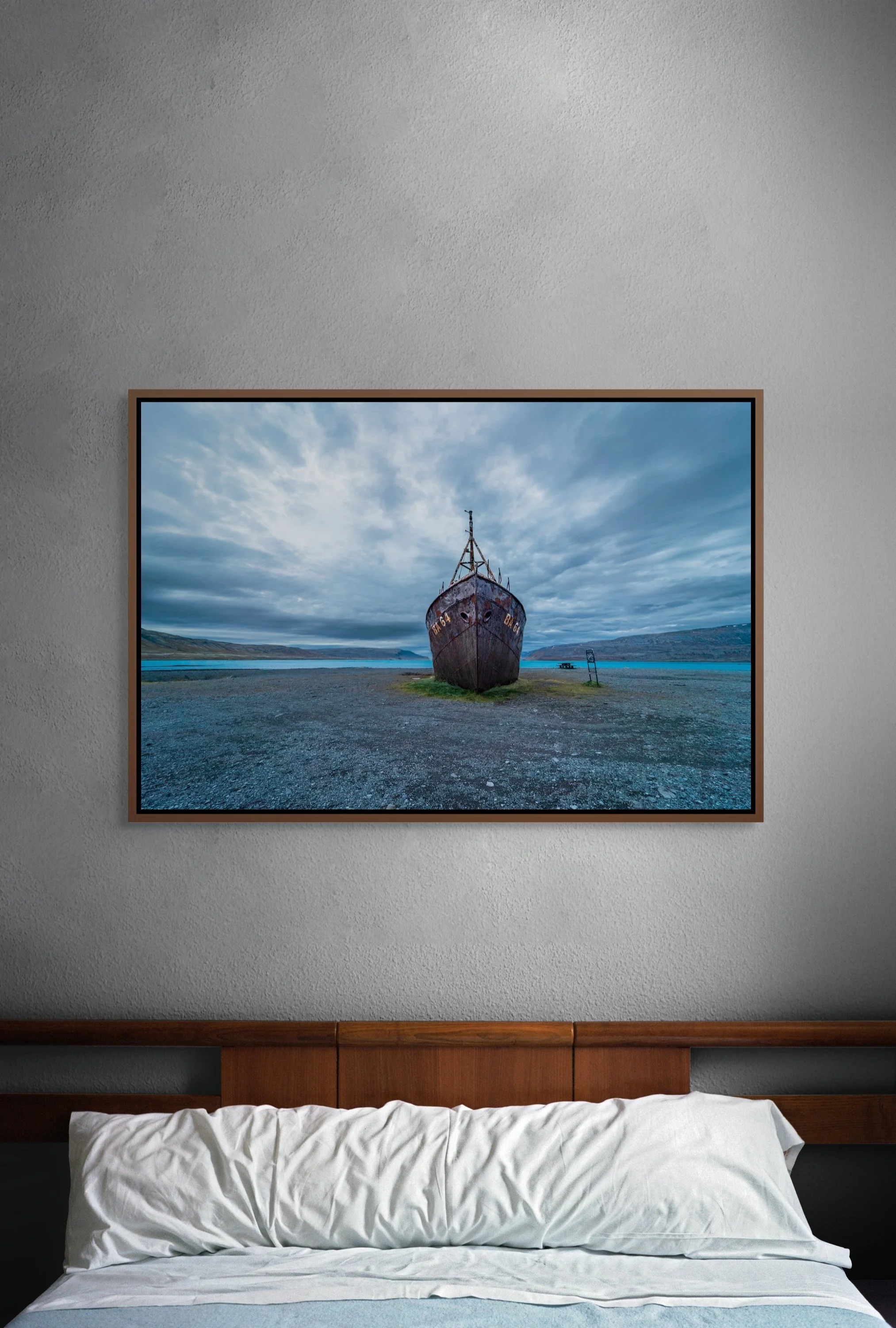 Close-up of The Last Voyage in a alder brown floating frame mounted on a textured grey wall.