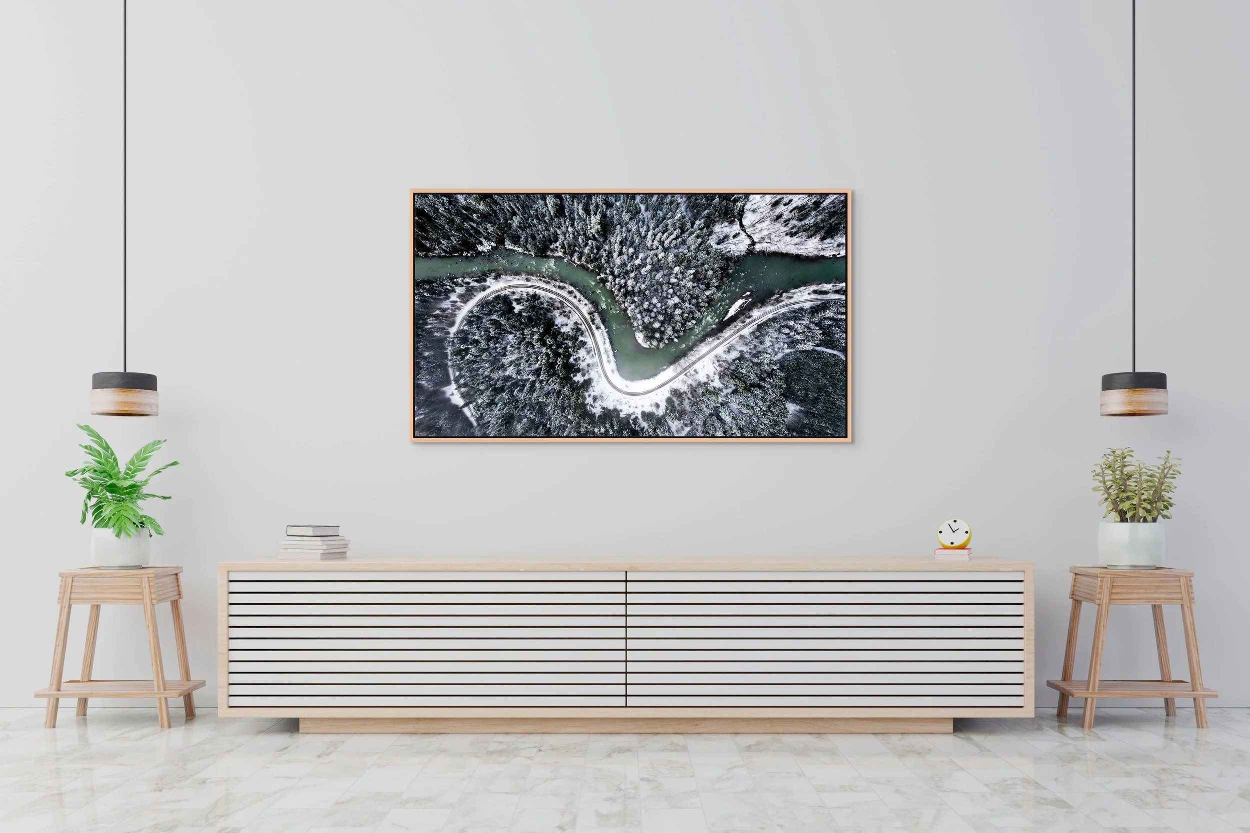 The Hidden Curve, floating Natural Oak frame, hanging above a minimalist white sideboard with plants.