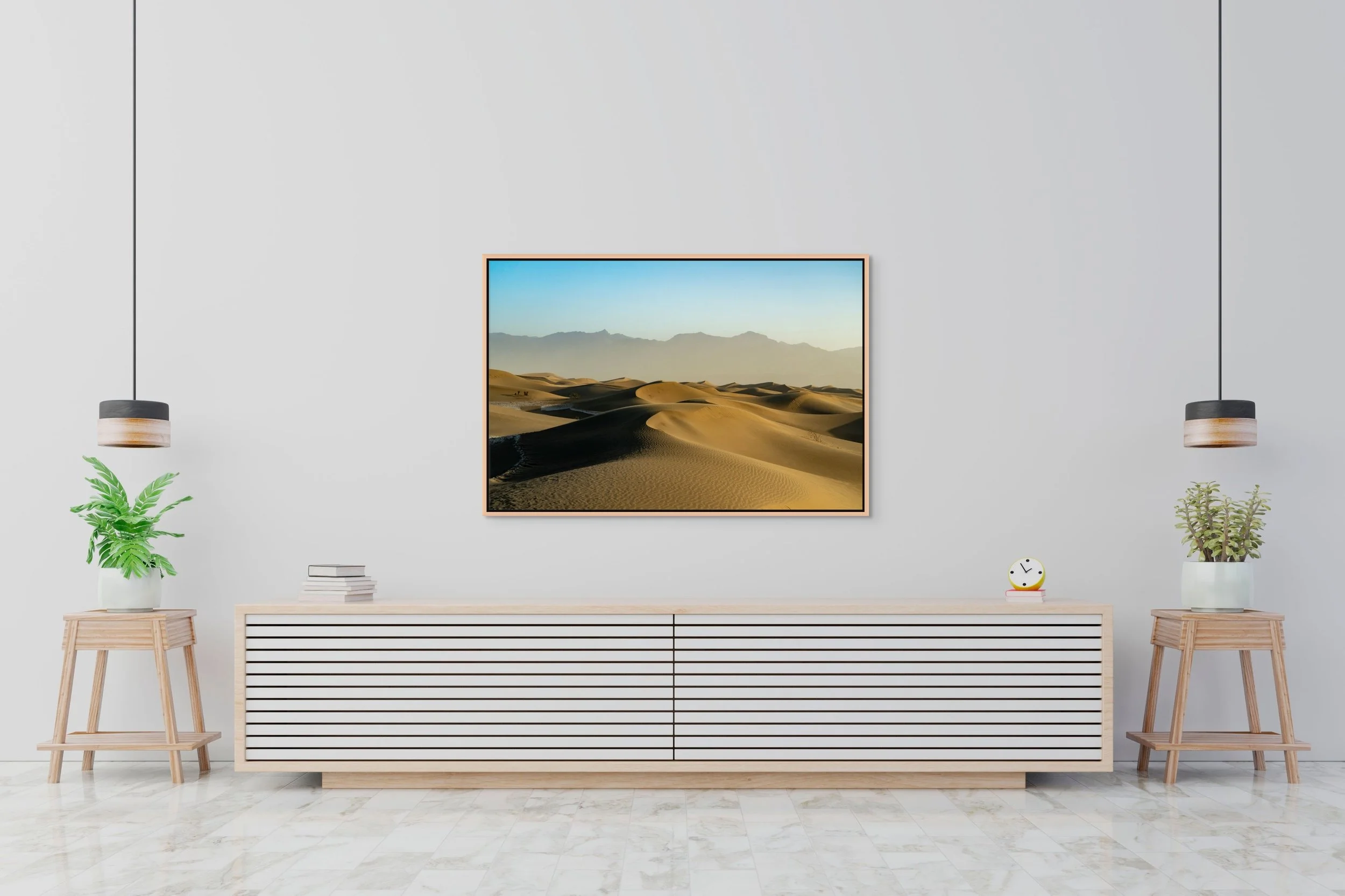 Where Shadows Rest — golden dunes at sunrise, framed in natural oak floating wood frame over a minimalist white credenza in a clean, gallery-style room.