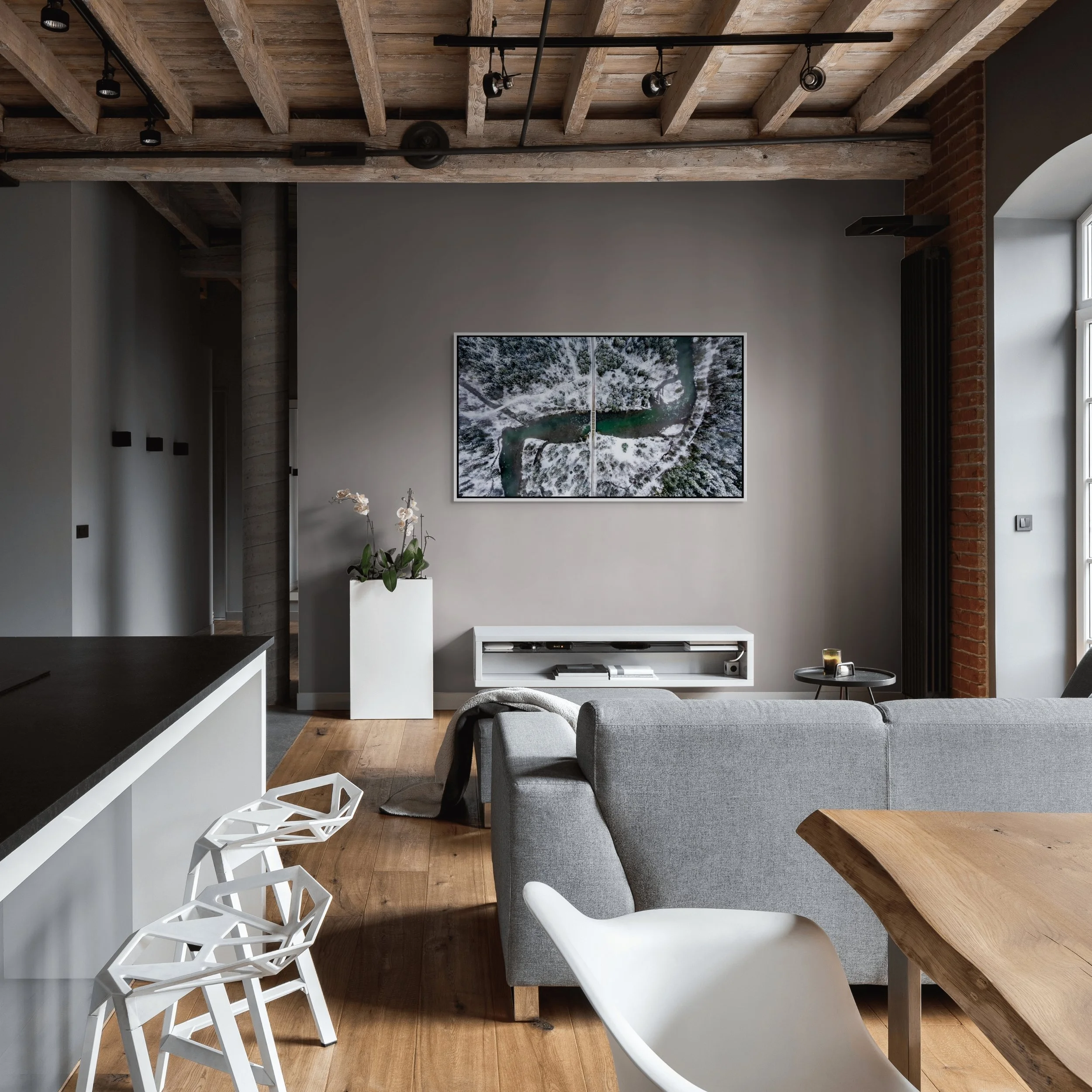 The Hidden Crossing, framed in White floating frame, in an industrial loft with exposed beams, kitchen island, and grey seating.