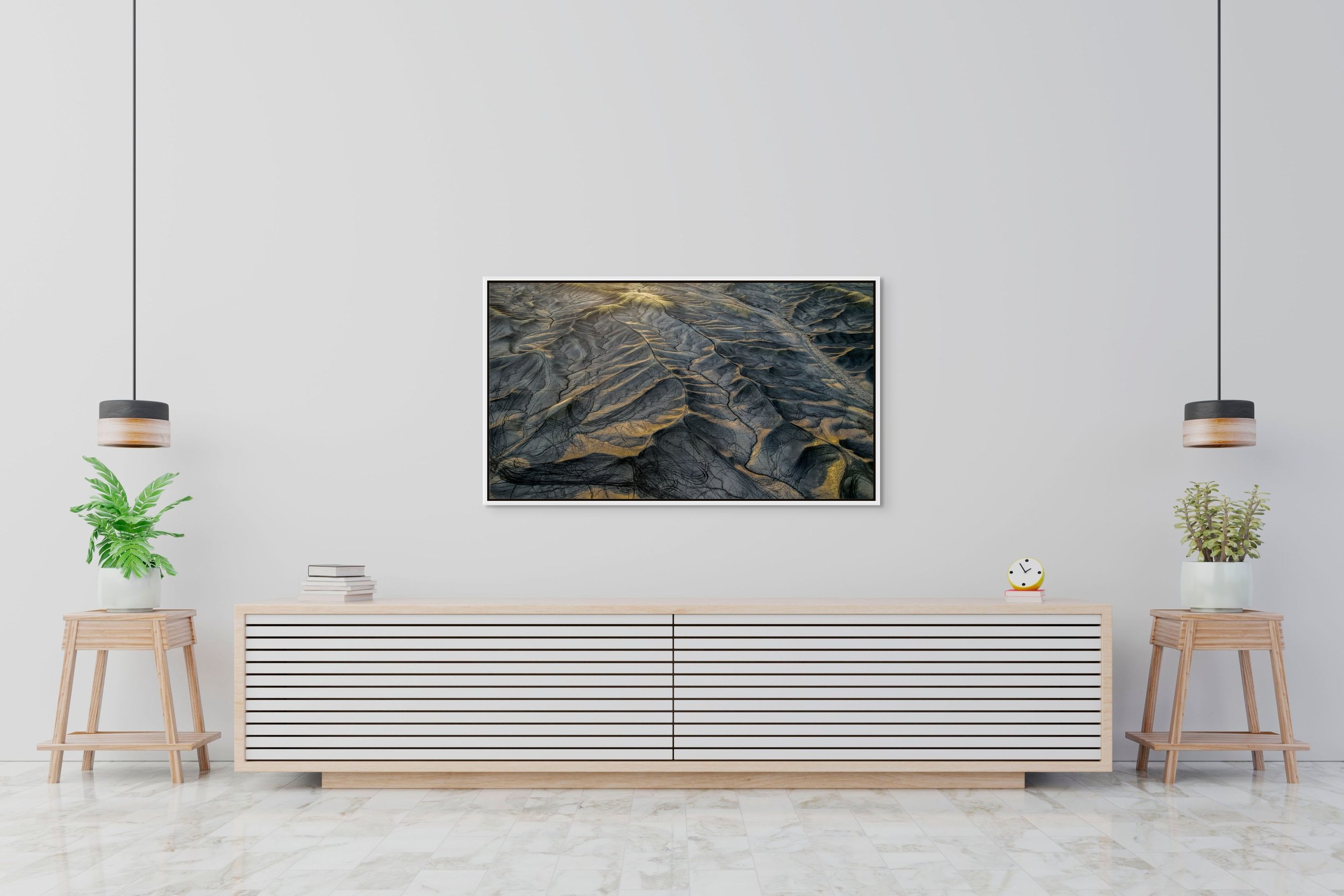 Erosion Lines in a floating white frame, hanging above a minimalist sideboard with pendant lights and plants.