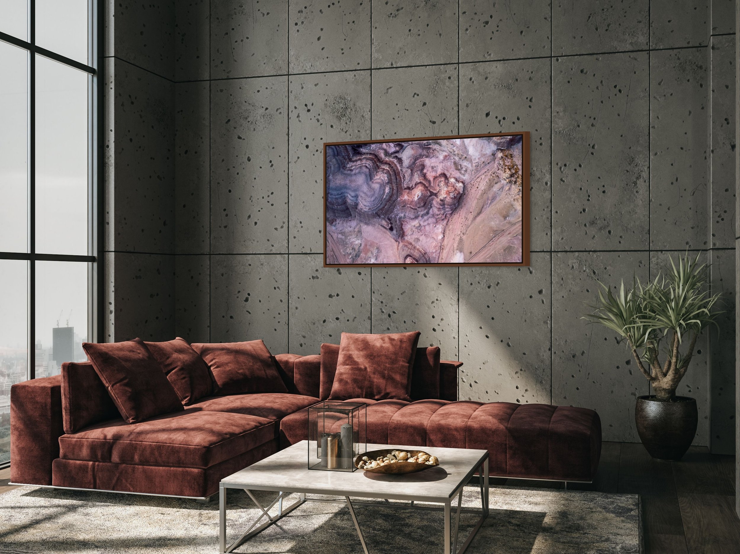 Small in Time — aerial bentonite-hill patterns in mauve and cream, framed in alder brown floating wood frame in a warm living room.