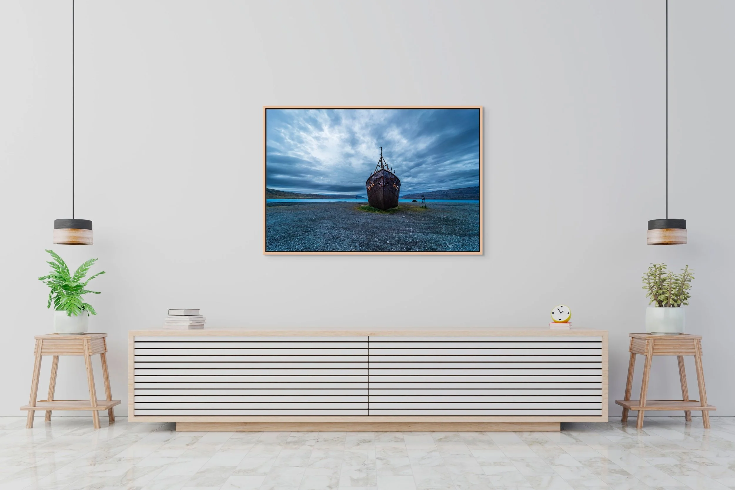 The Last Voyage in a natural oak floating frame centered above a long white console in a soft grey living room.