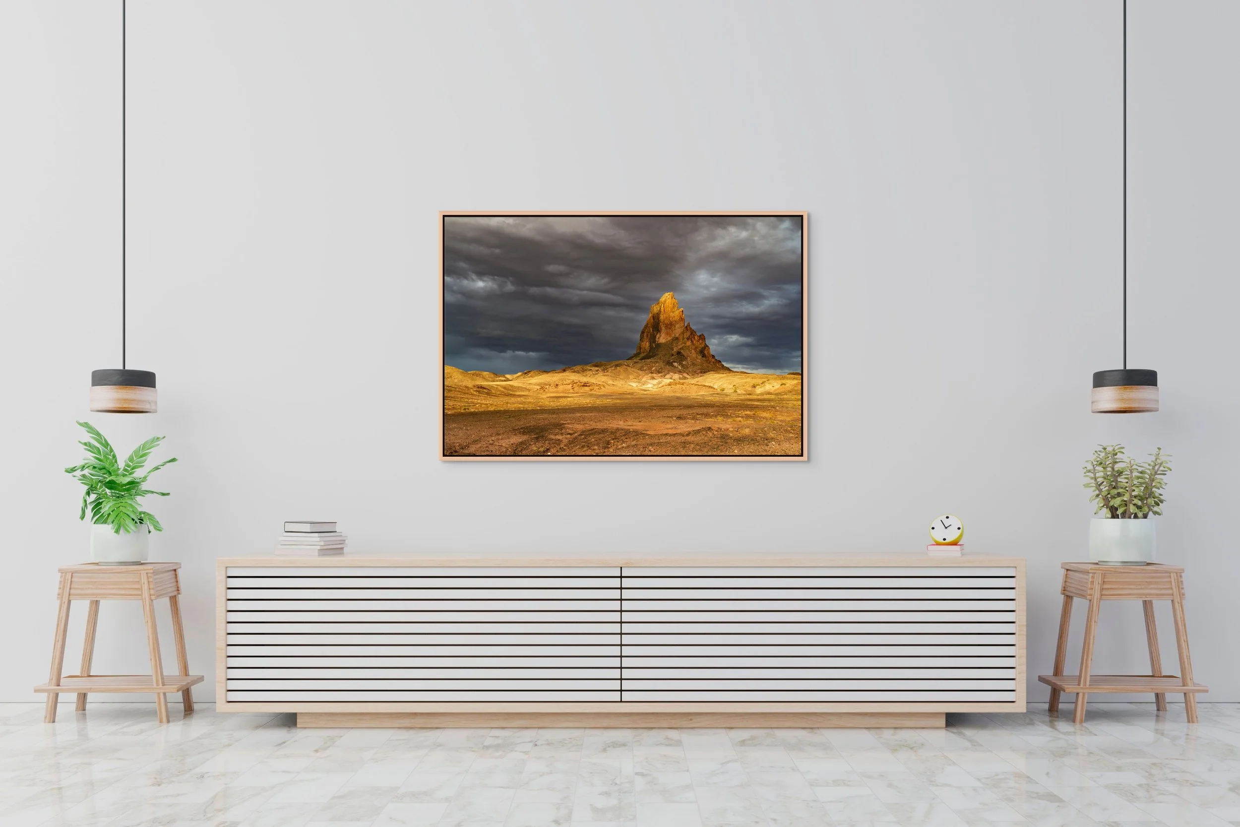 Sentinel of Stone in a floating Natural Oak frame, centered above a long low sideboard in a bright, minimalist space.