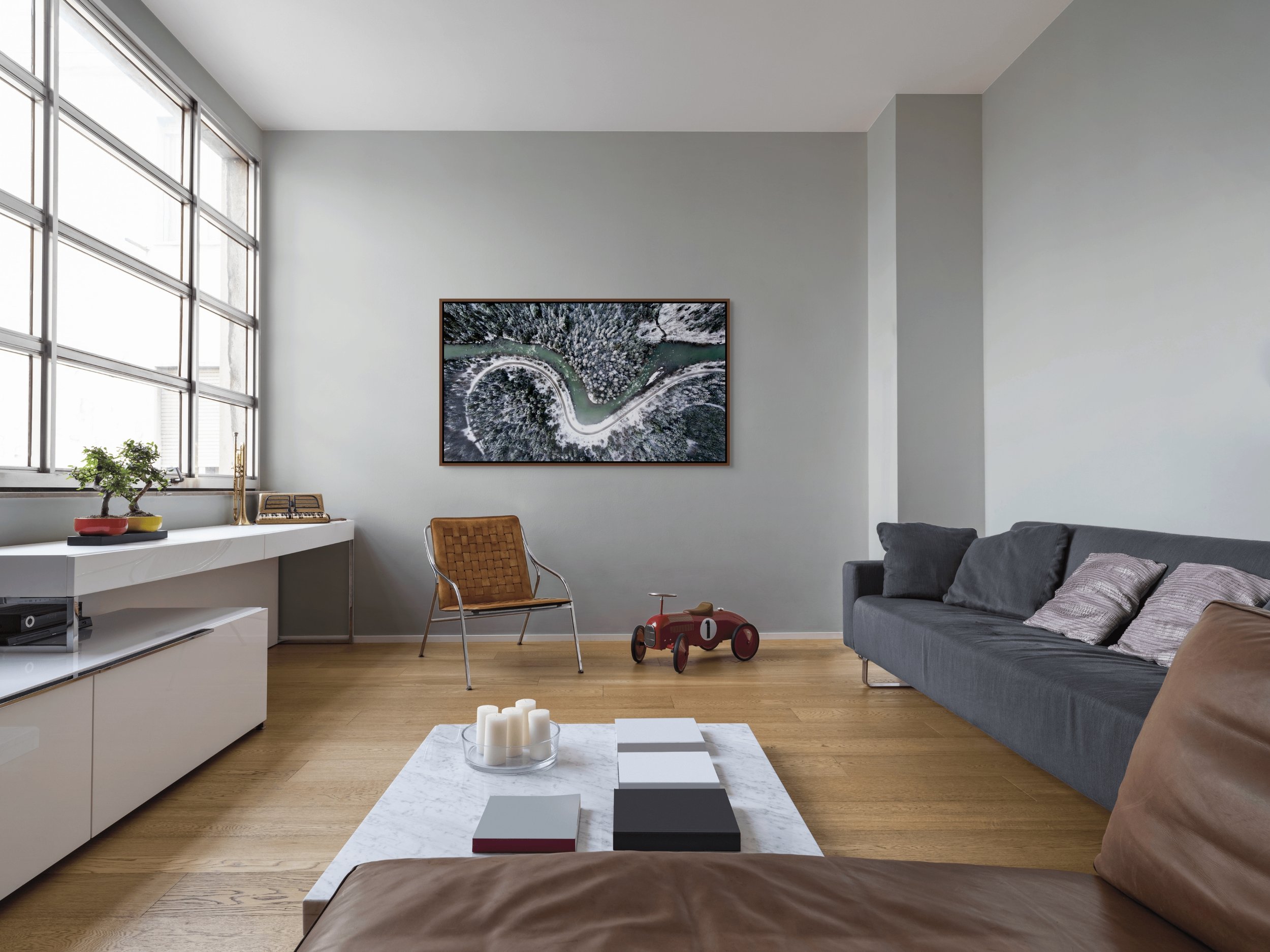 The Hidden Curve, floating Alder Brown frame, styled in a bright living room with low table and natural light.