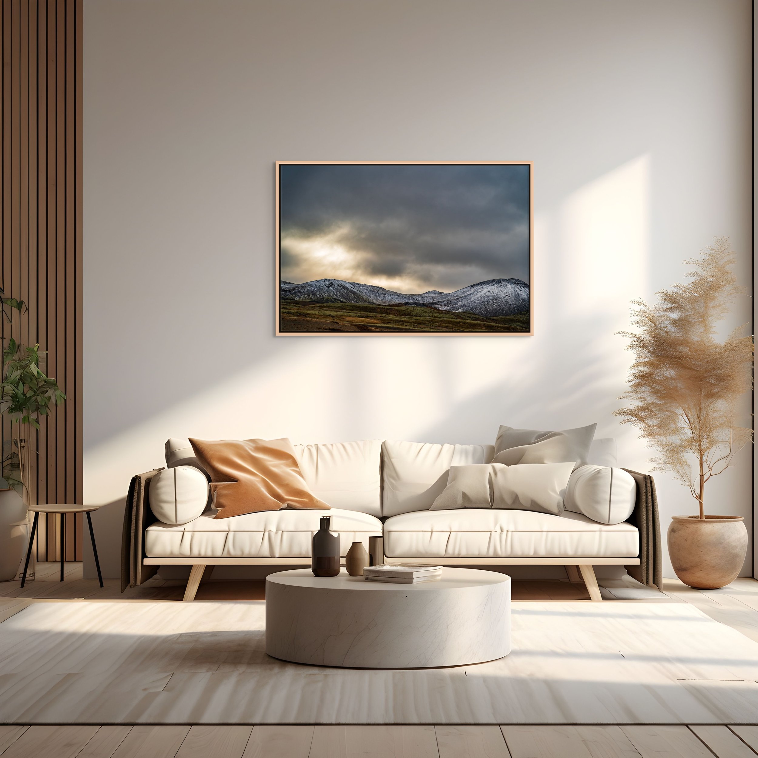 Snow, Then Silence in a floating Natural Oak frame, over a light tan sofa with round coffee table and pampas grass in a bright living room.