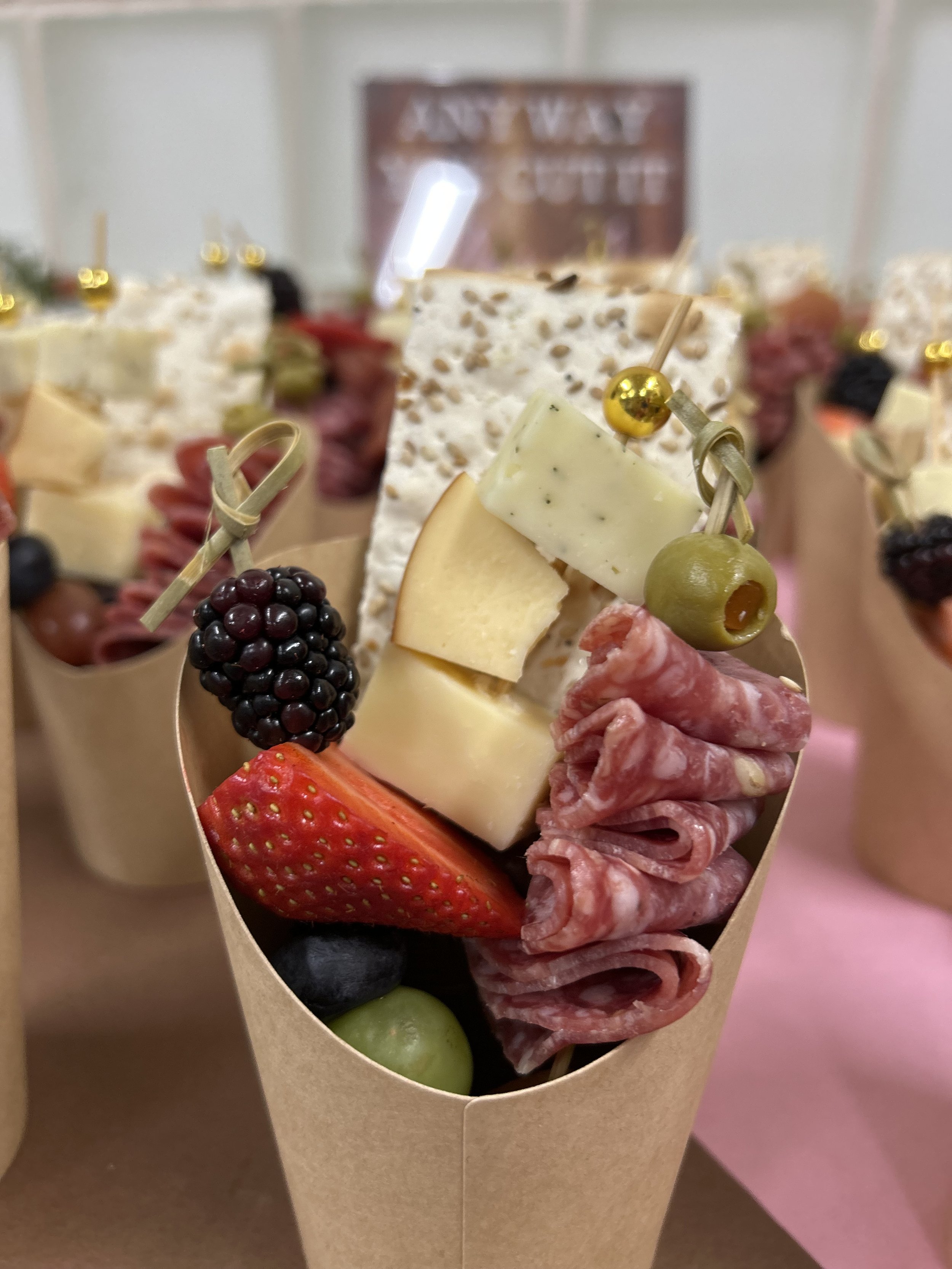 Kraft paper cups hold premade assortments of fruits, meats, and cheeses to help teachers and staff grab and go as needed.
