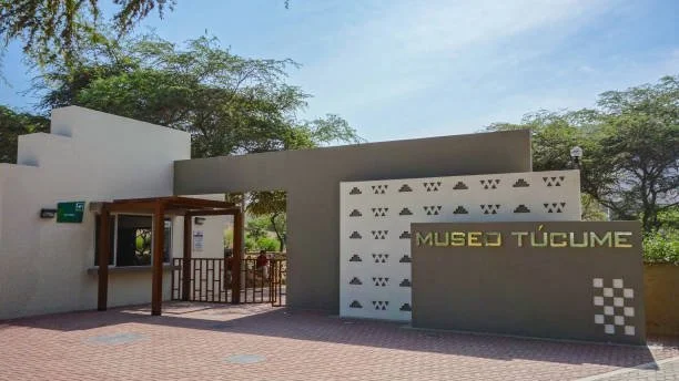 Entrada del Museo Túcume mostrando un cartel con el nombre y un diseño de patrones geométricos en la pared.